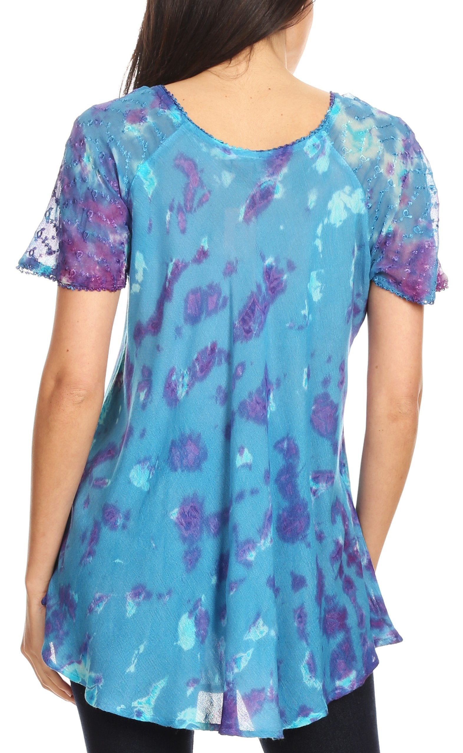 Woman wearing a blue floral patterned tunic with a plain background