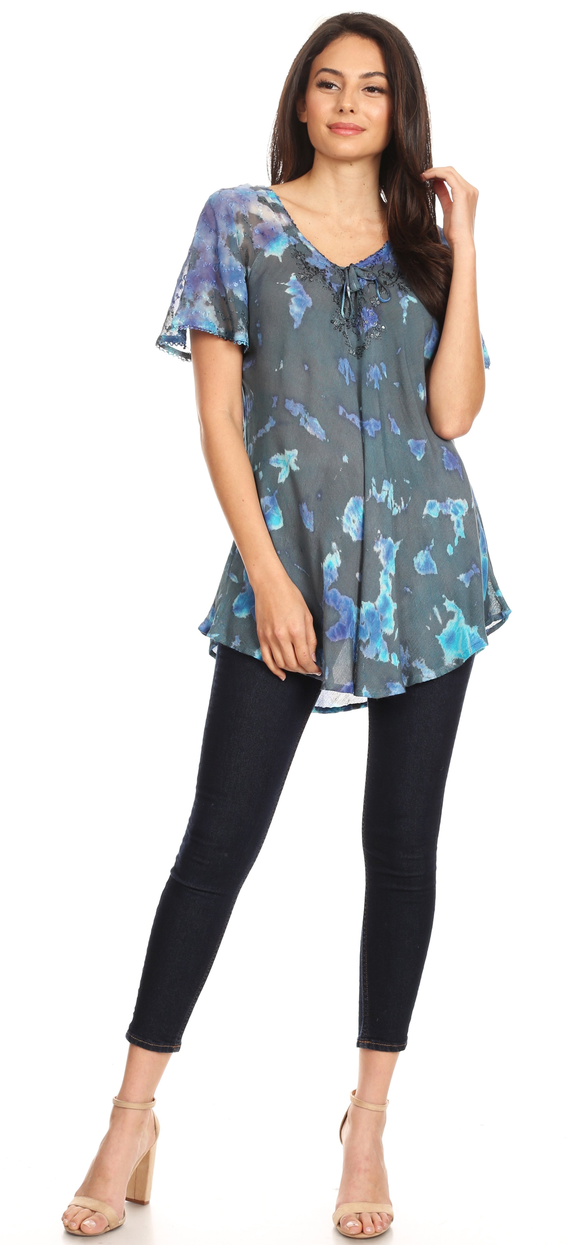 Woman wearing a floral blouse and black pants on a white background