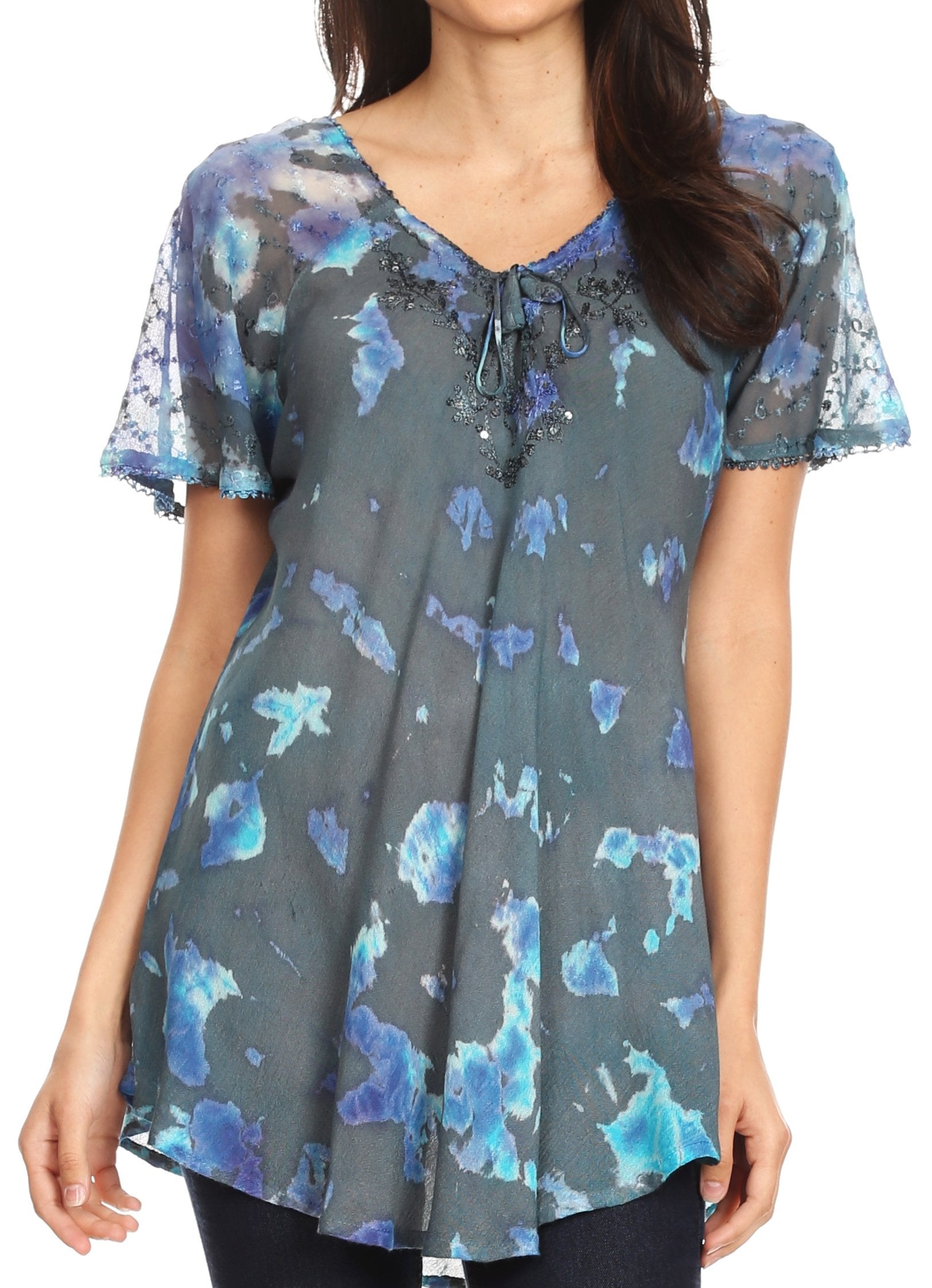 Woman wearing a short-sleeve blouse with blue floral pattern on a gray background