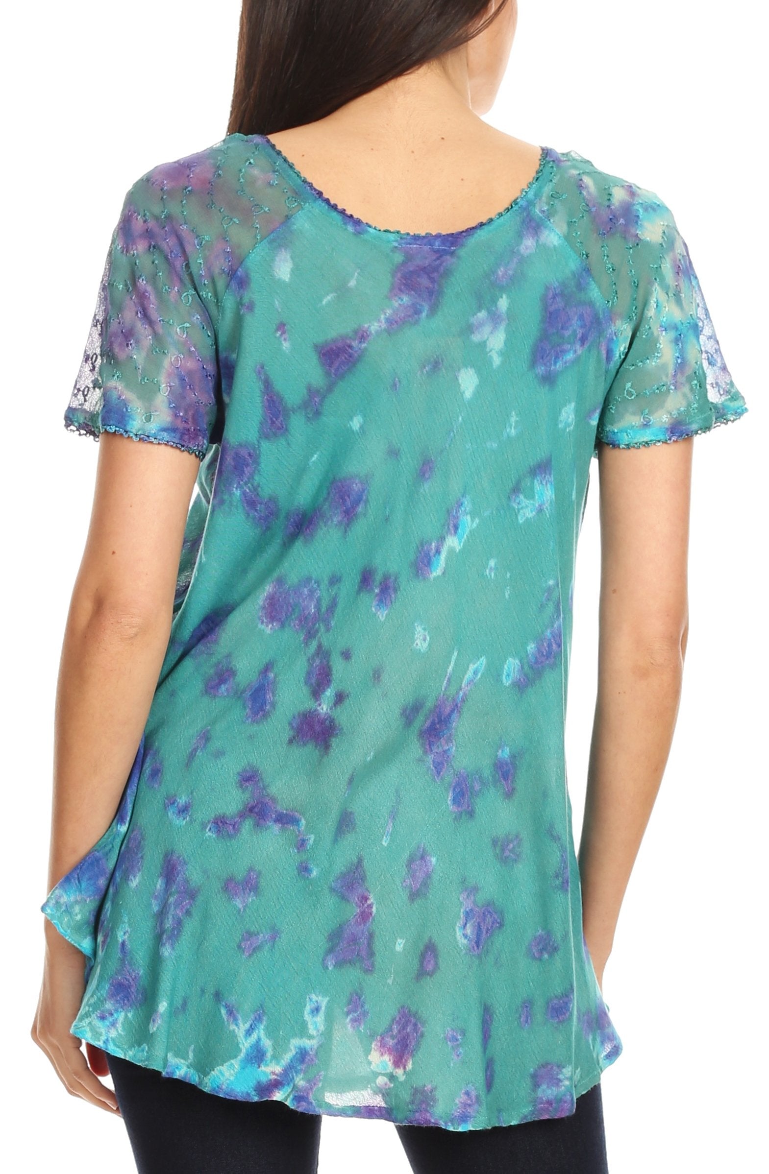 Woman wearing a teal and purple floral patterned top on a white background