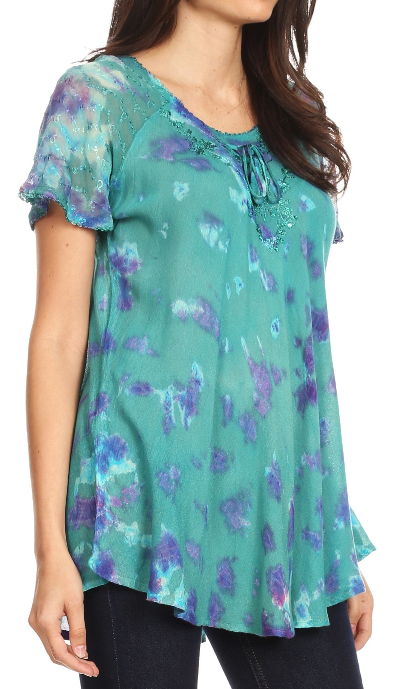 Woman wearing a teal floral blouse with a blurred background