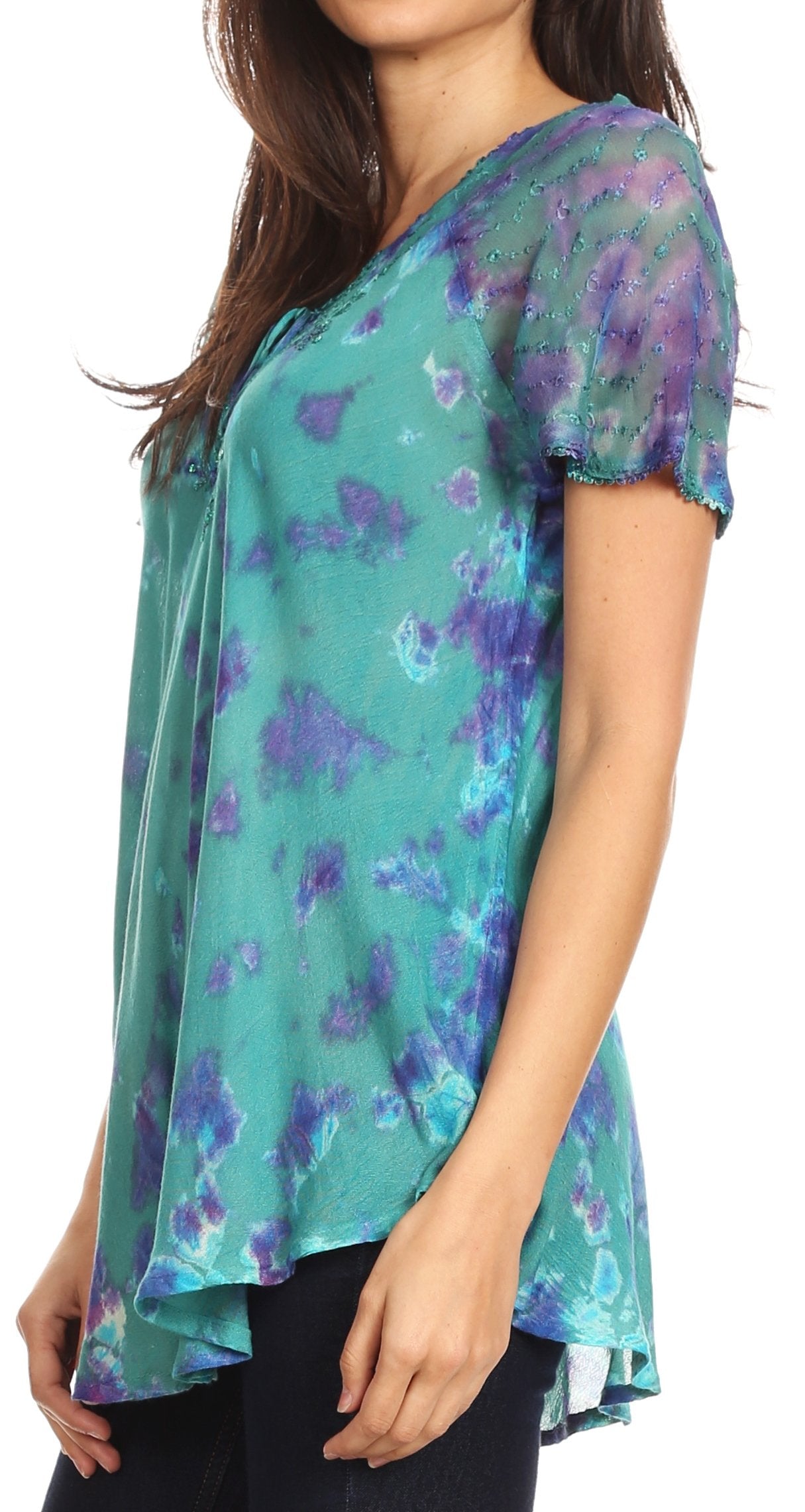 Woman wearing a teal and purple floral patterned top on a white background