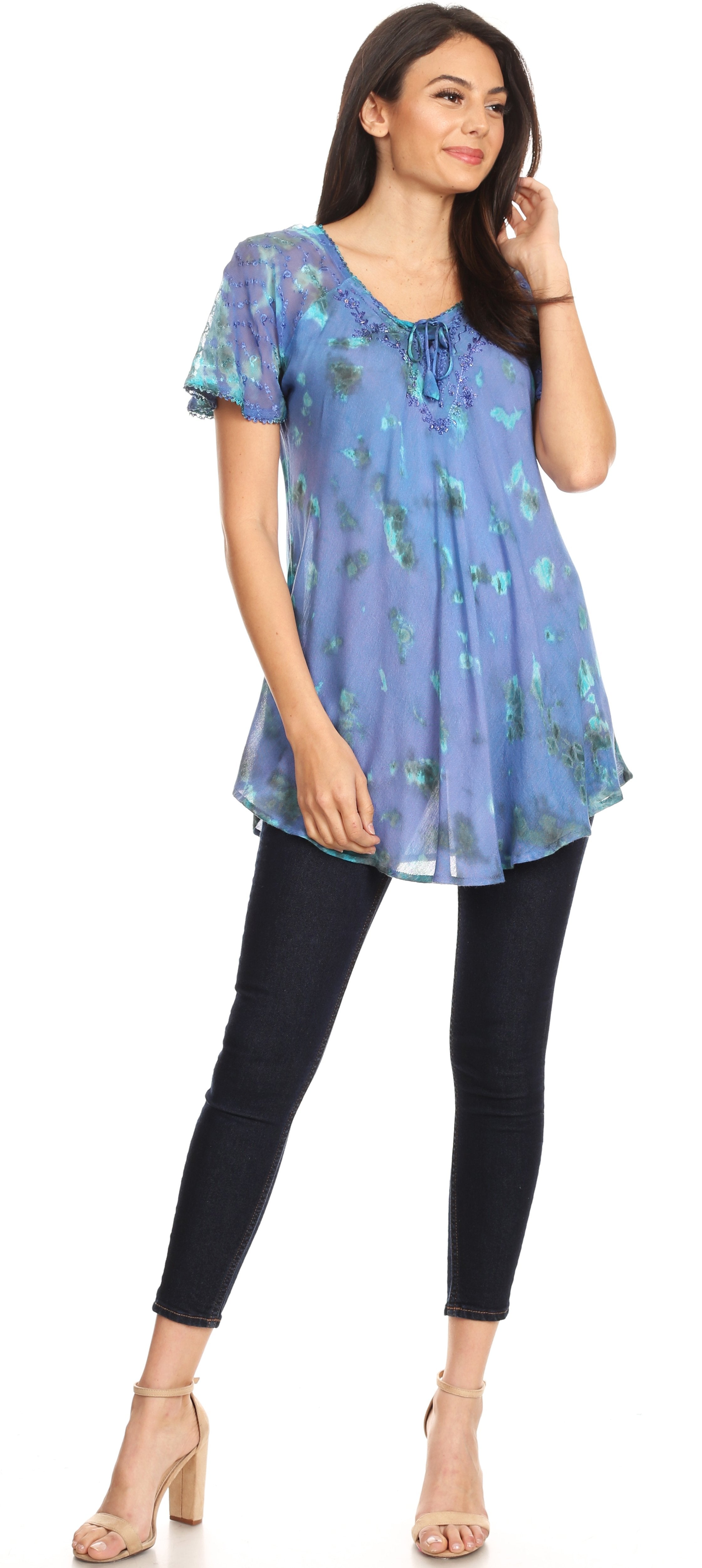 Woman wearing a blue floral top and black pants on a white background