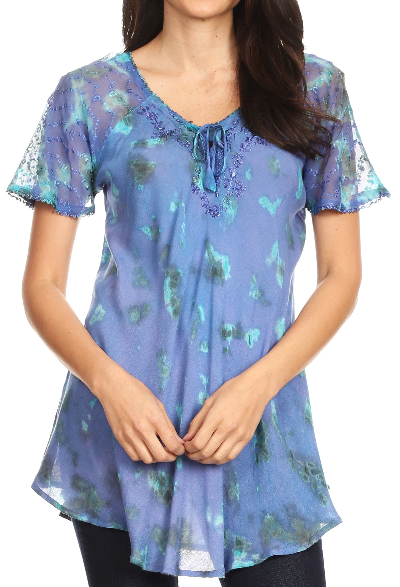 Woman wearing a blue floral print top with lace sleeves on a white background
