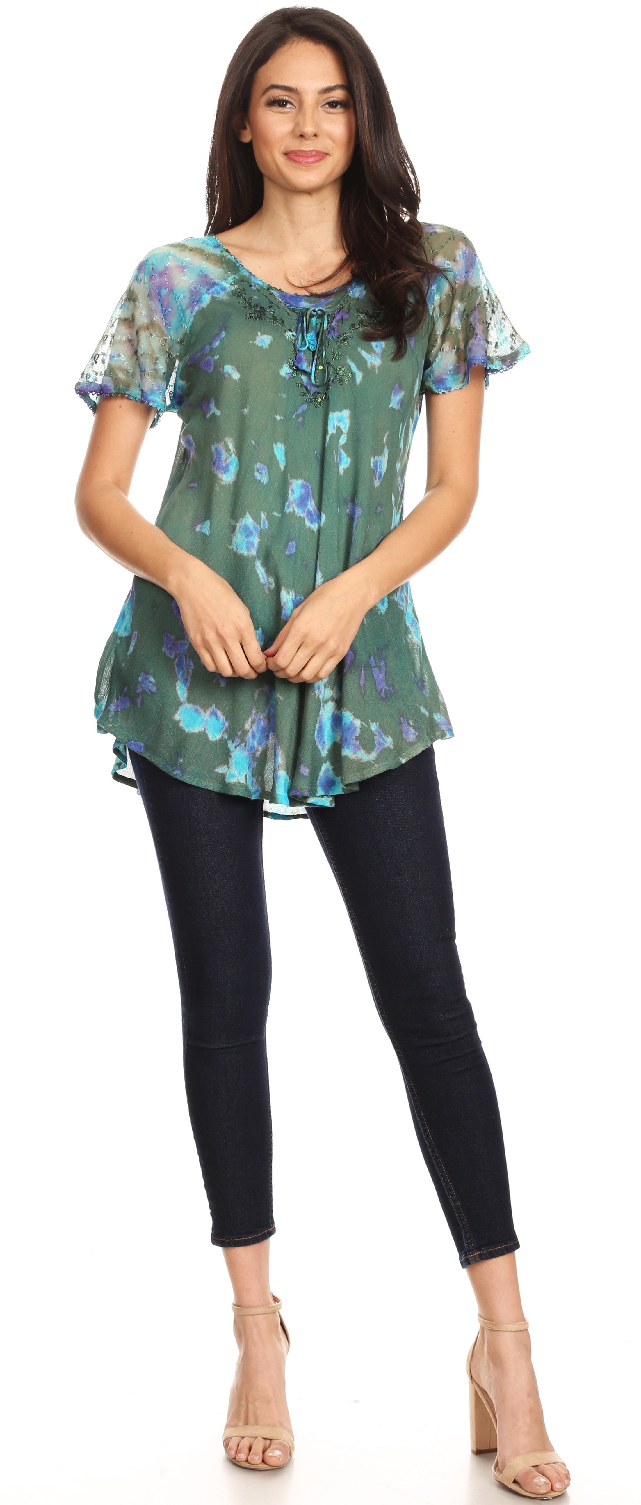 Woman wearing a green floral blouse and black pants on a white background