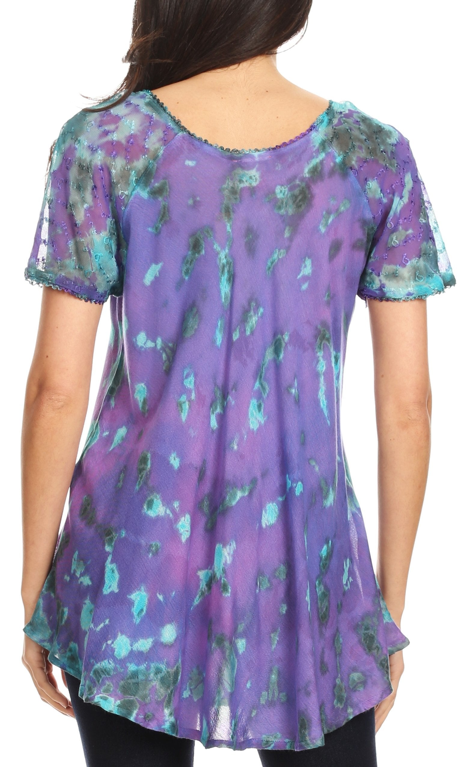 Purple and green patterned top worn by a person on a white background