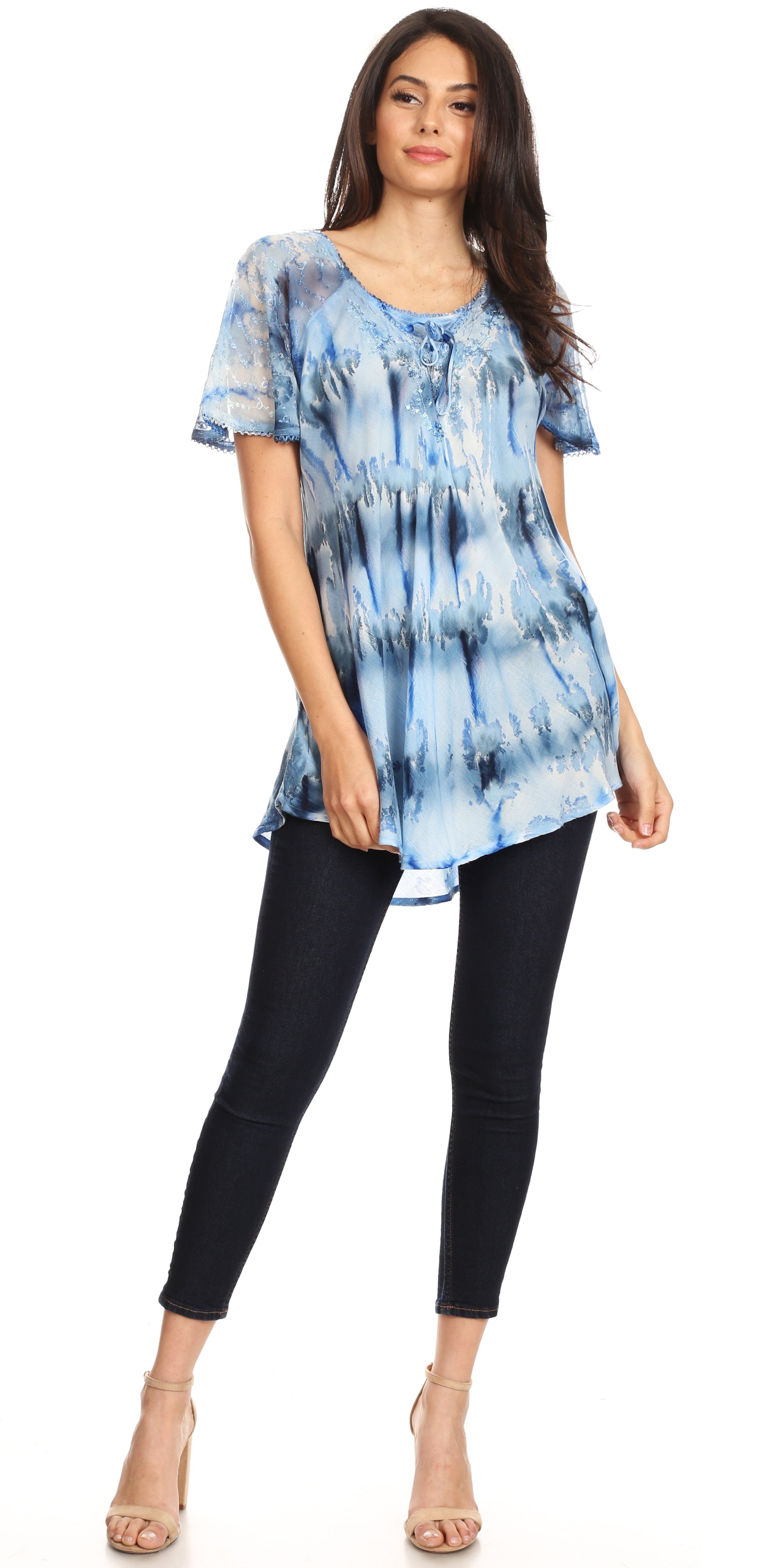 Woman wearing a blue tie-dye top and black pants on a white background
