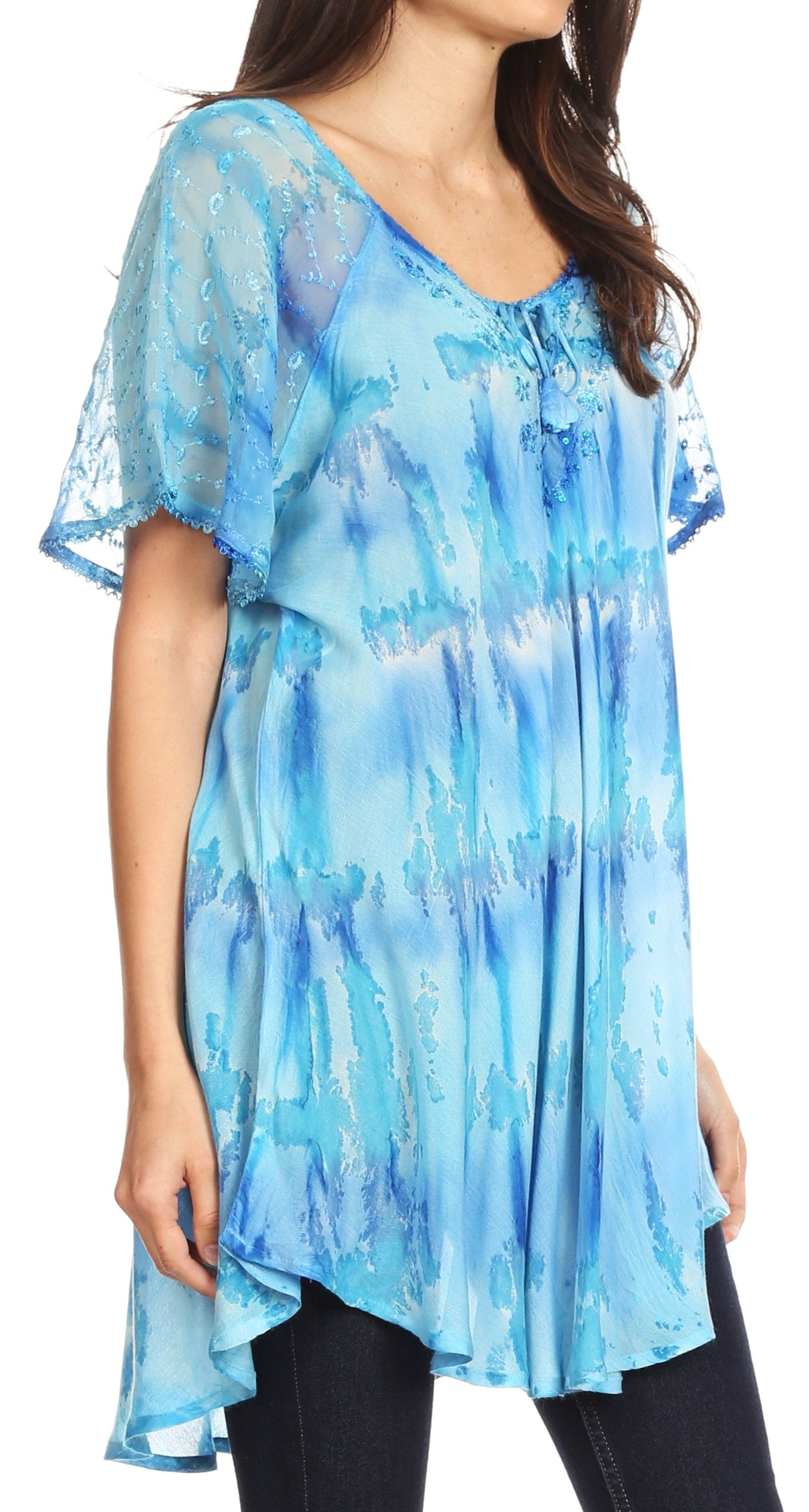 Woman wearing a blue tie-dye shirt with sheer sleeves on a white background