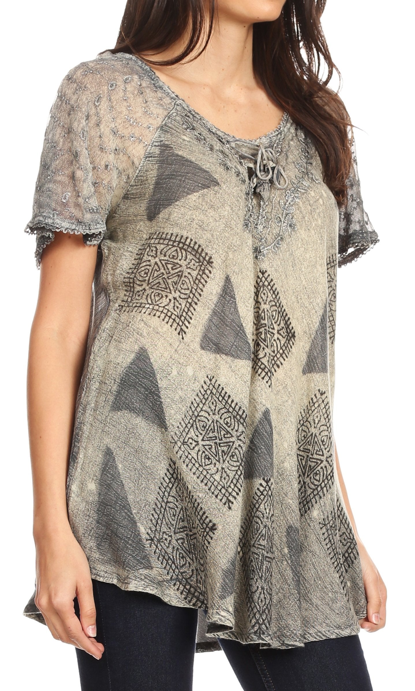 Woman wearing a patterned blouse with sheer sleeves on a white background