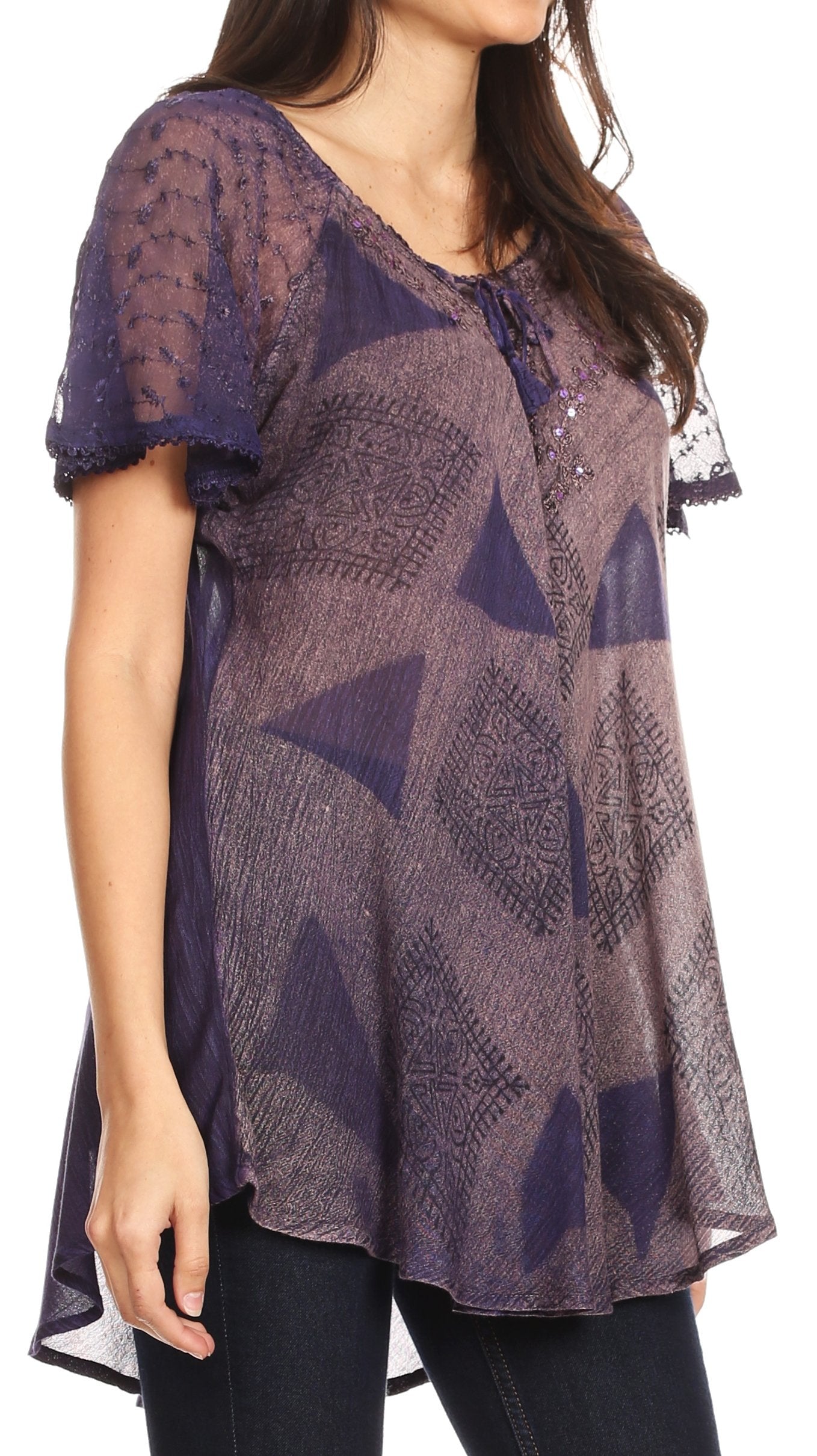 Woman wearing a sheer purple patterned top with black pants on a white background