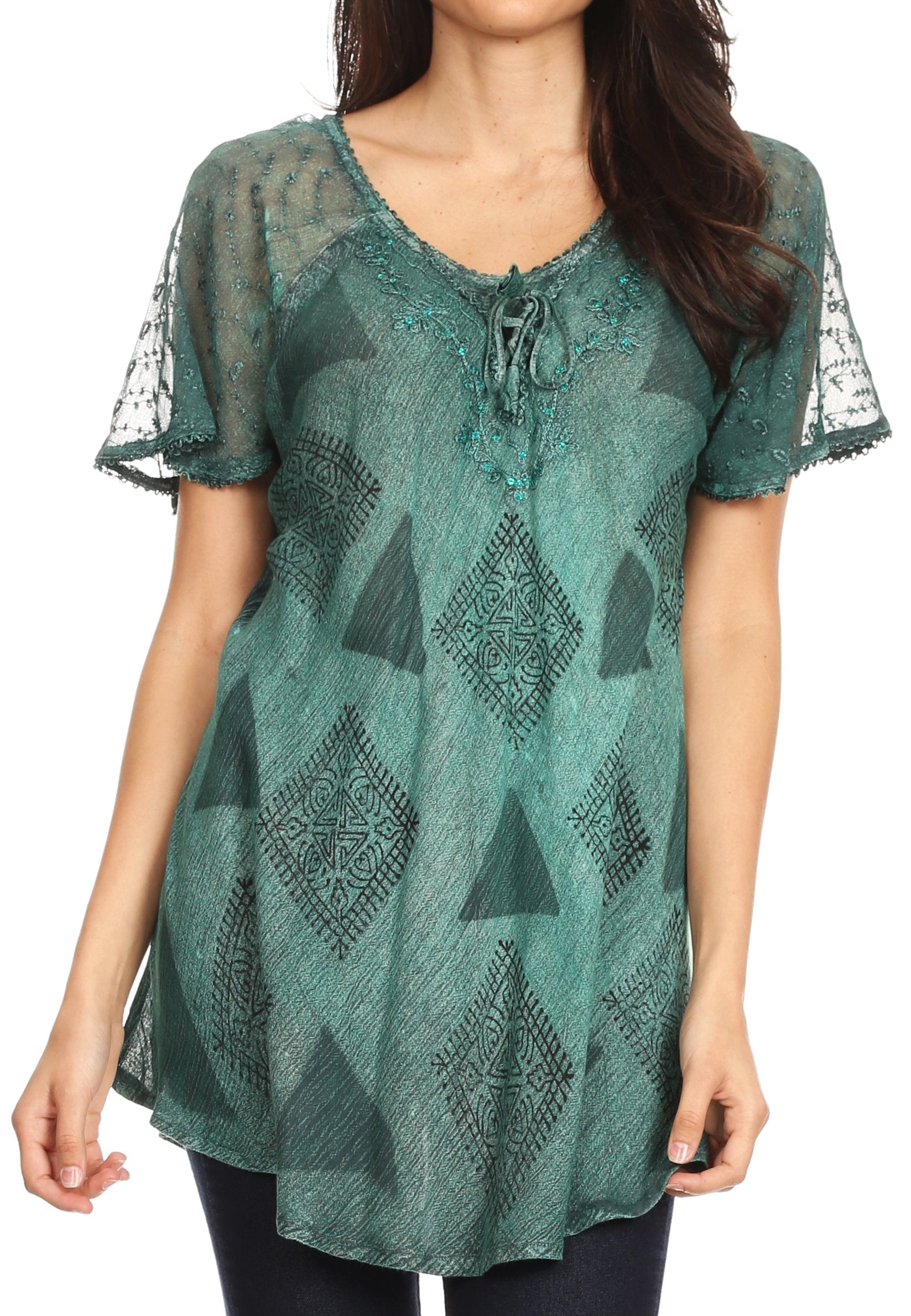 Woman wearing a green patterned blouse with sheer sleeves on a white background