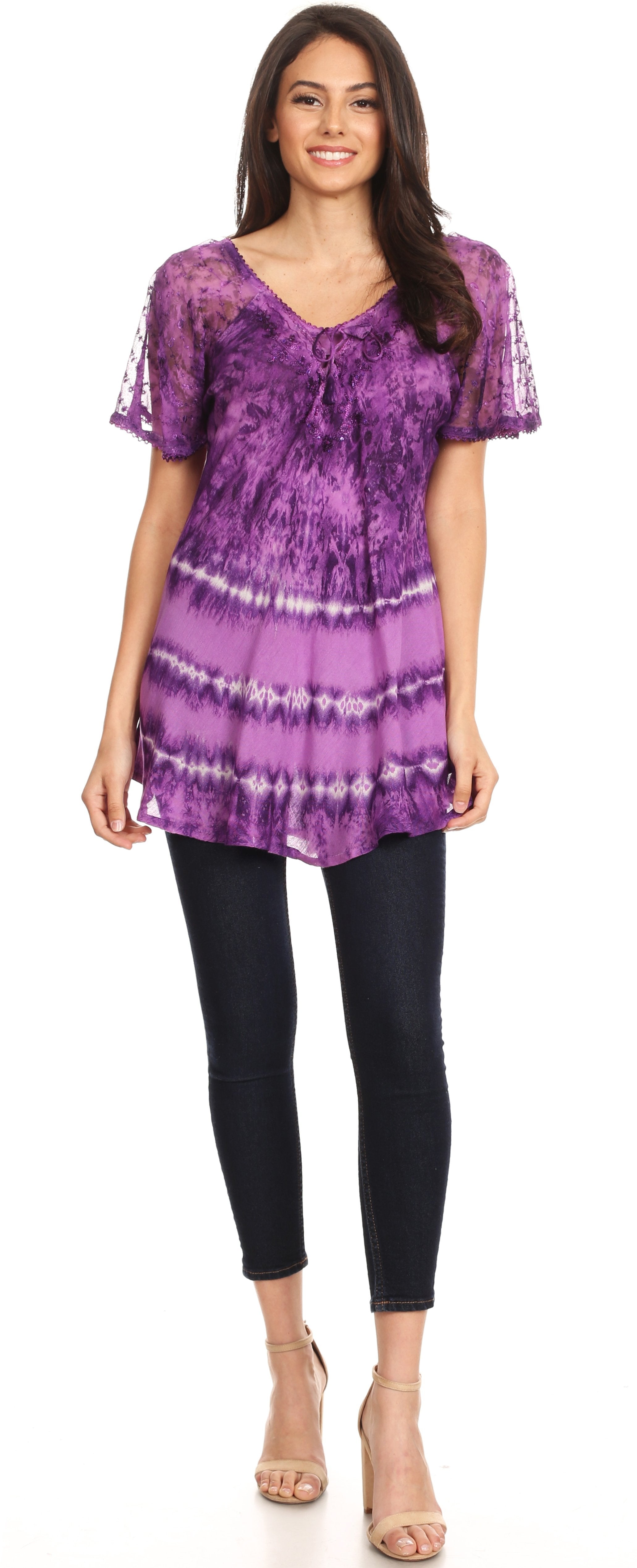 Woman wearing a purple tie-dye top and black pants on a white background