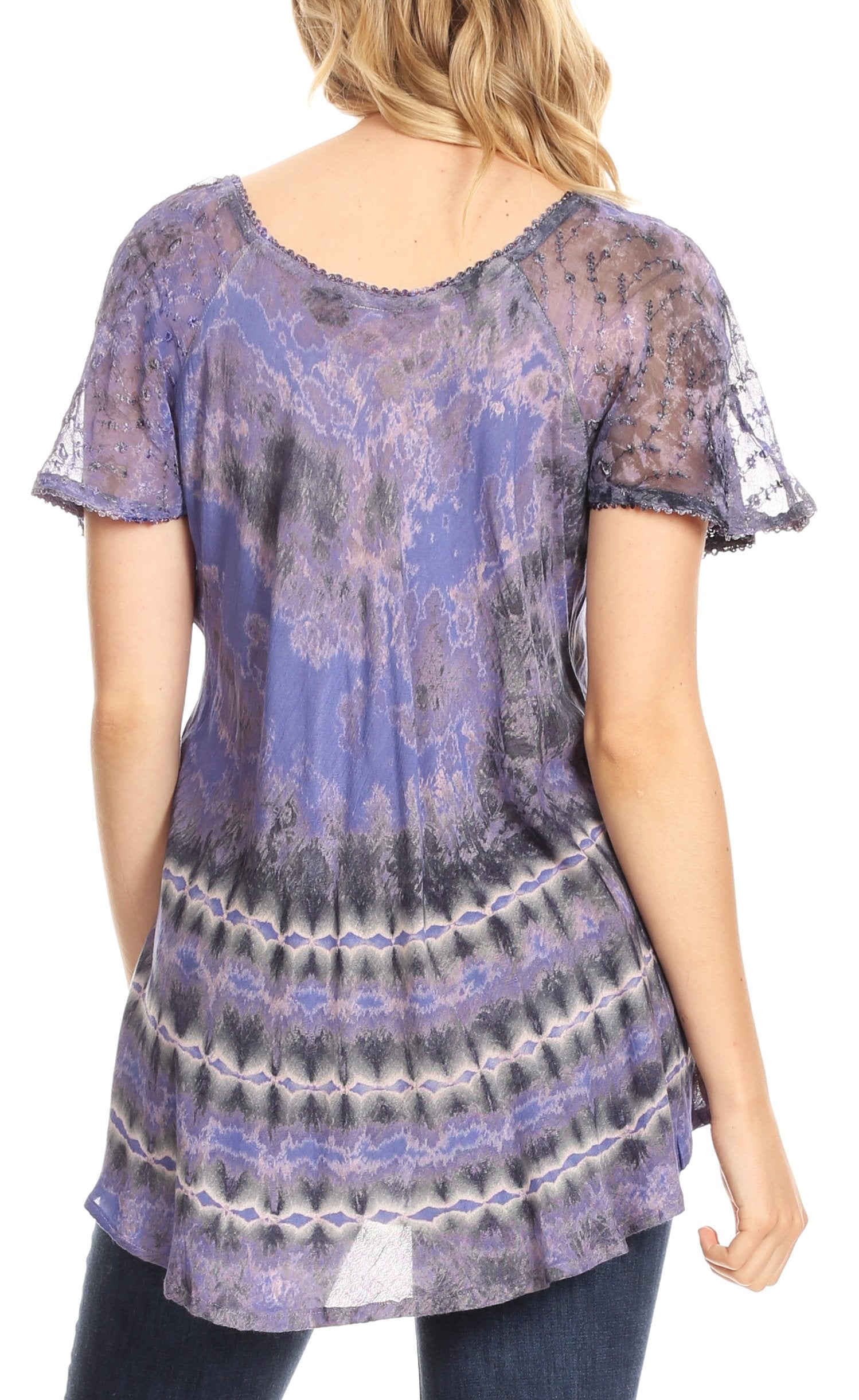 Woman wearing a short-sleeve, patterned tunic in purple and blue tones.