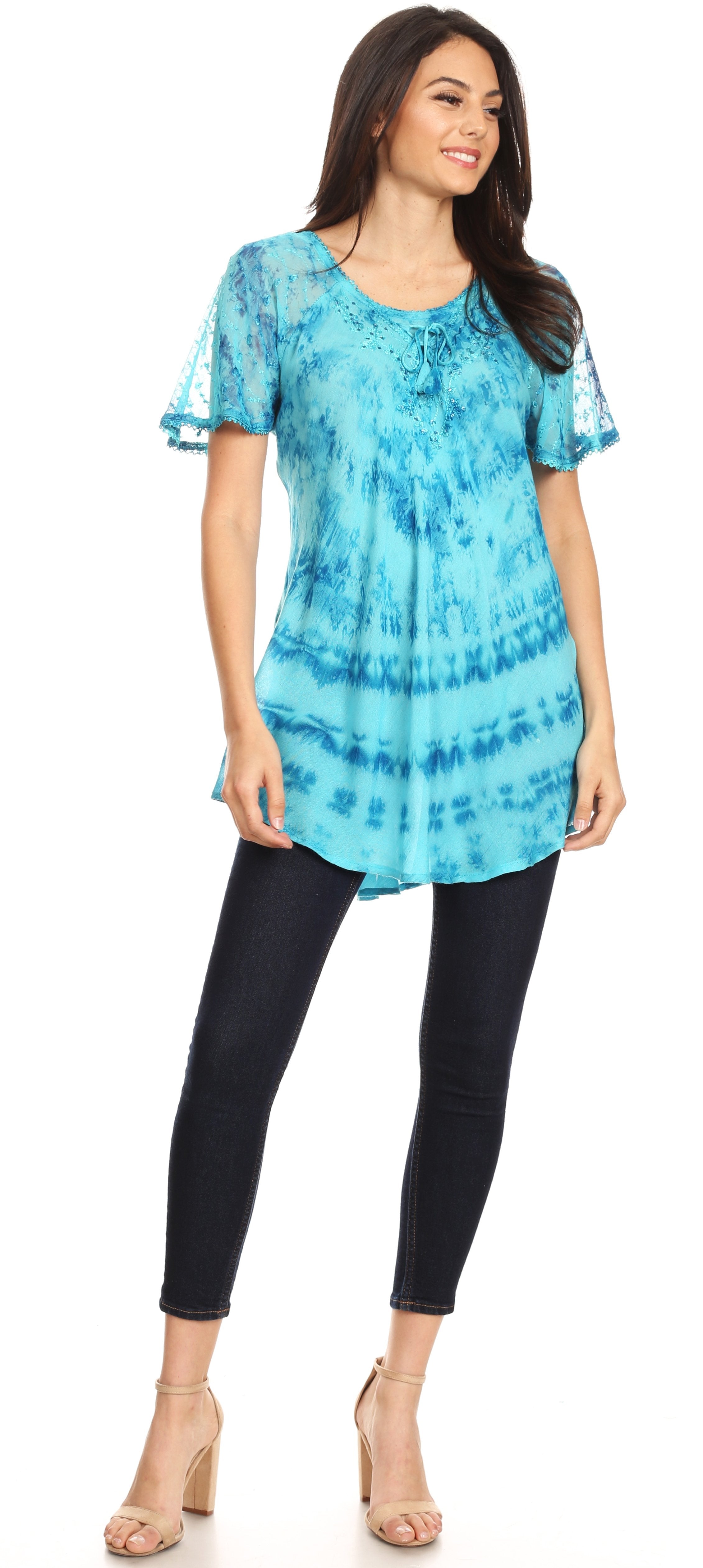 Woman wearing a blue tie-dye top and black pants on a white background