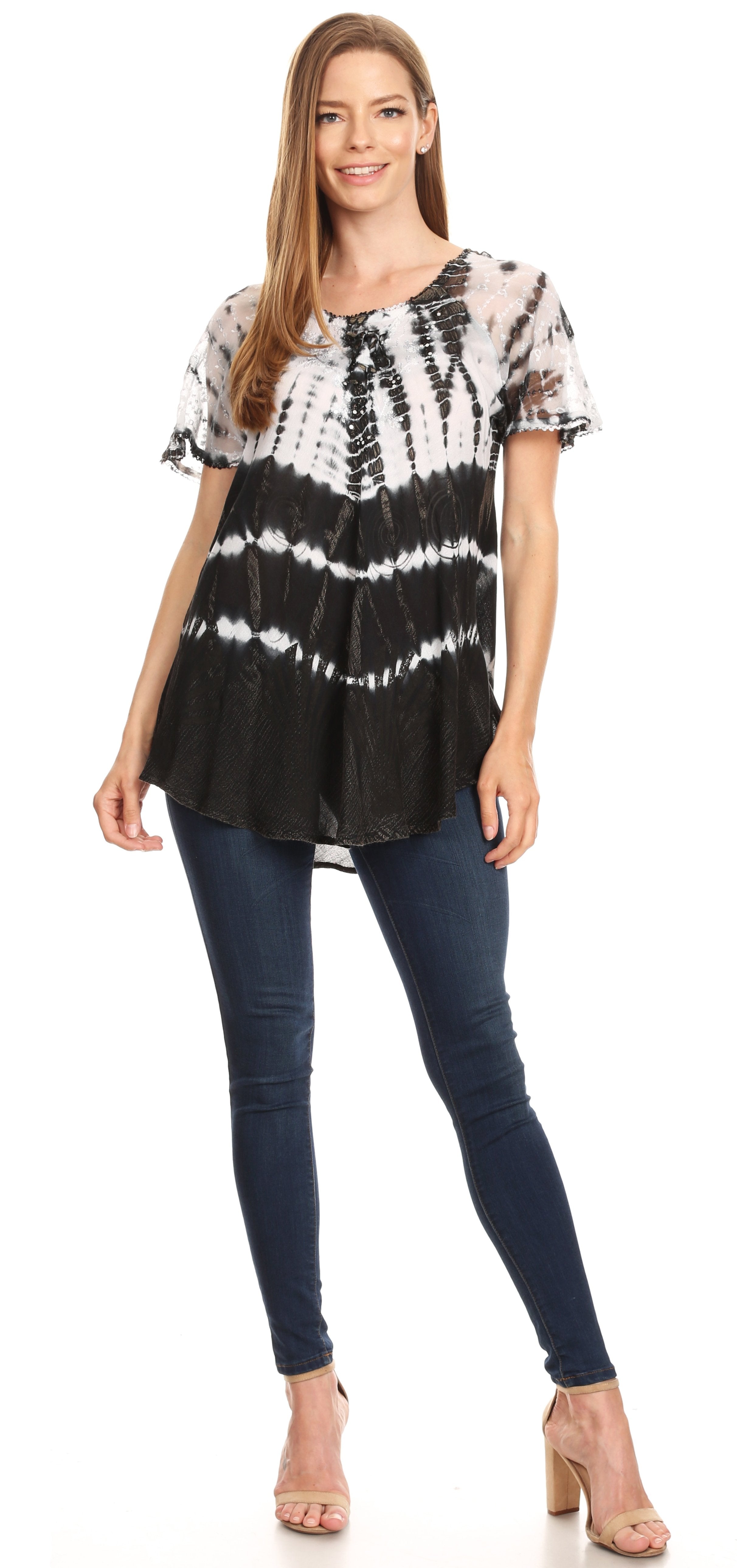 Woman wearing a black and white tie-dye top with blue jeans on a white background