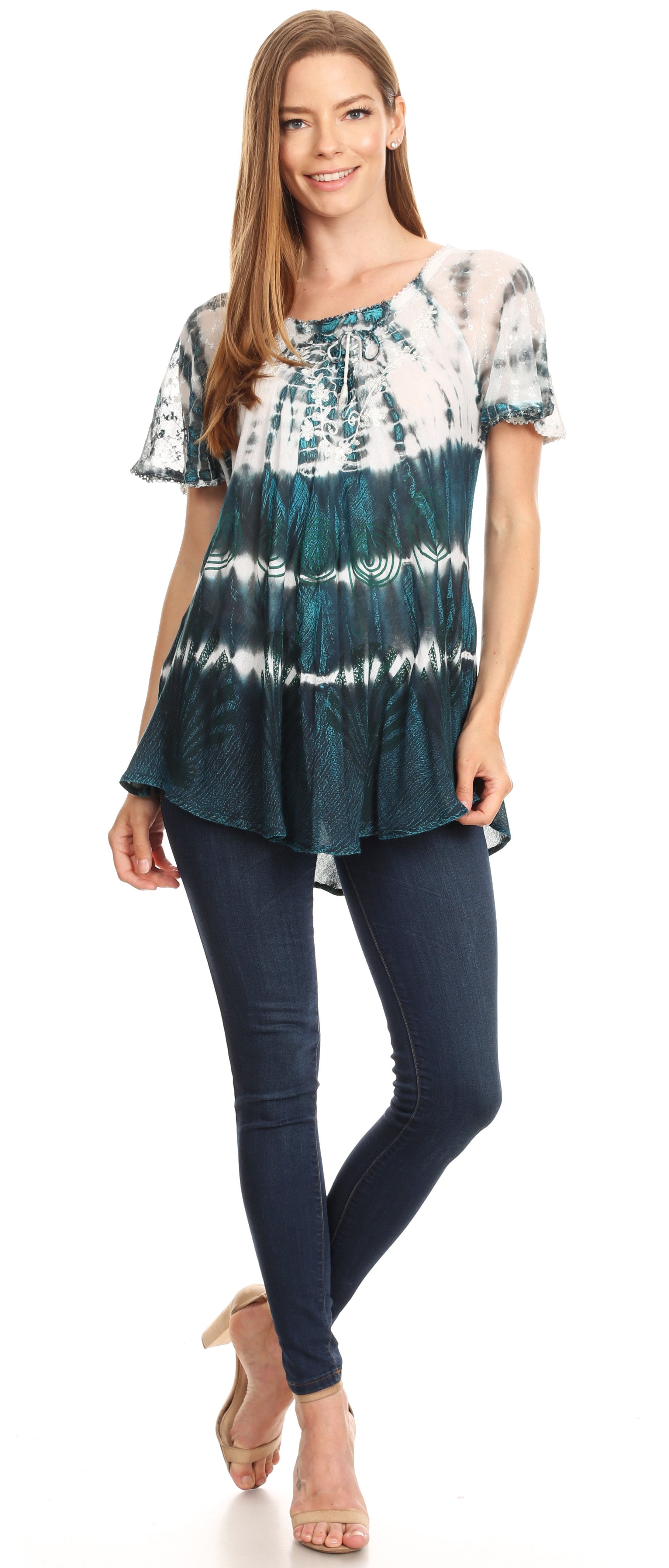 Woman wearing a tie-dye top and dark jeans on a white background
