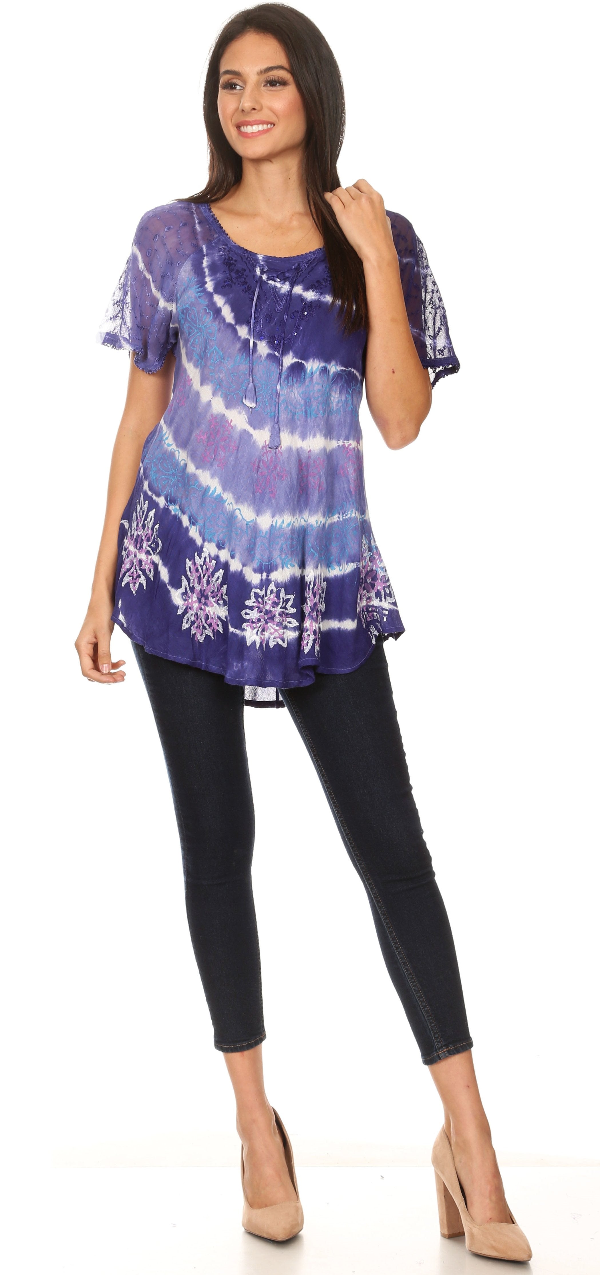 Woman wearing a tie-dye top and black pants on a white background