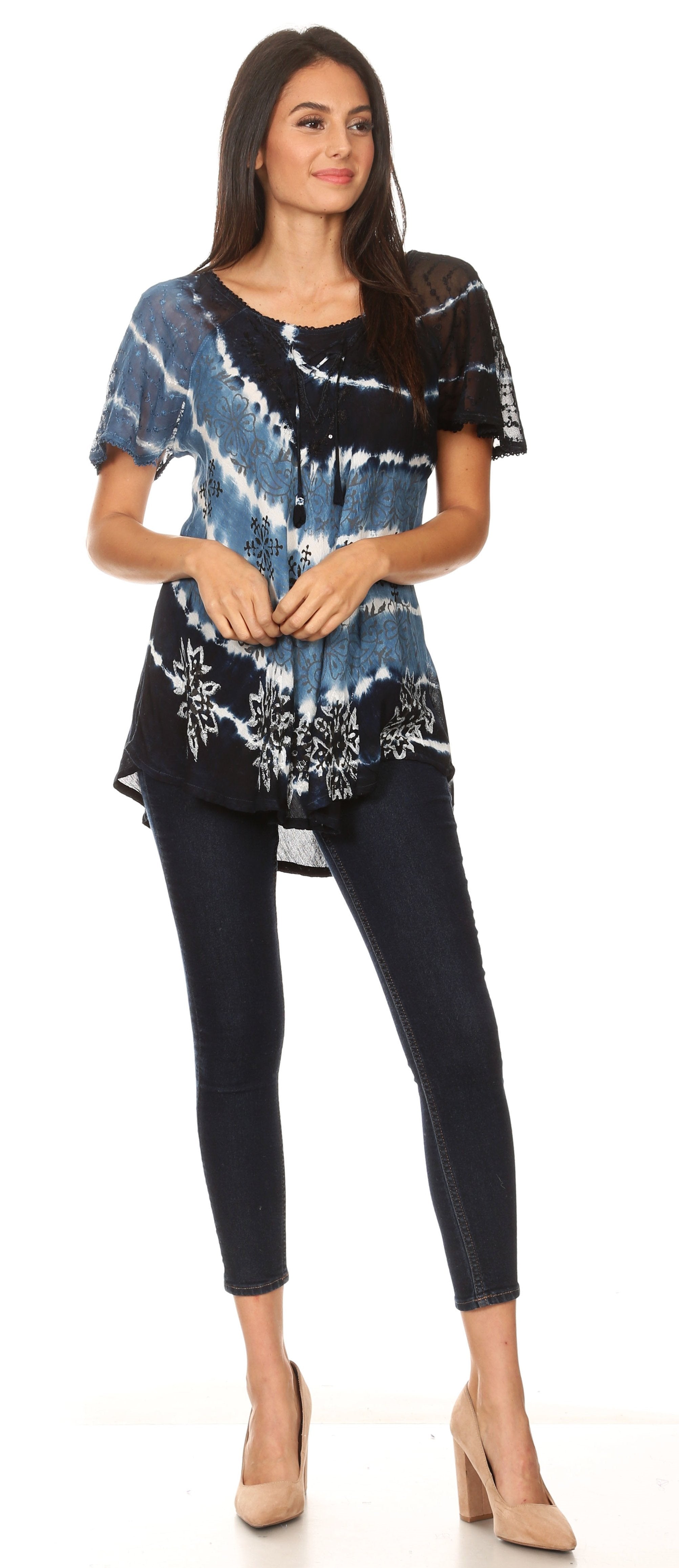 Woman wearing a tie-dye top and black pants on a white background