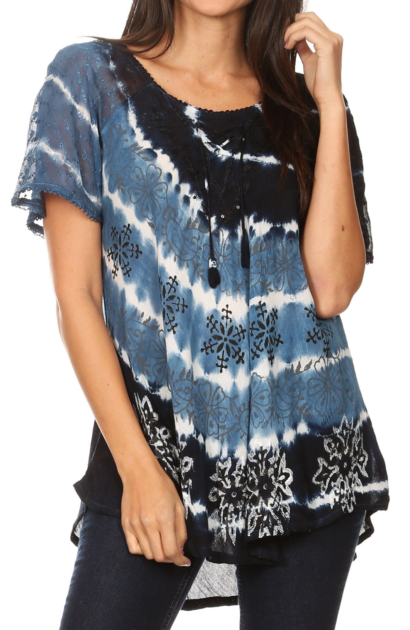 Woman wearing a tie-dye shirt with blue, black, and white pattern on a plain background