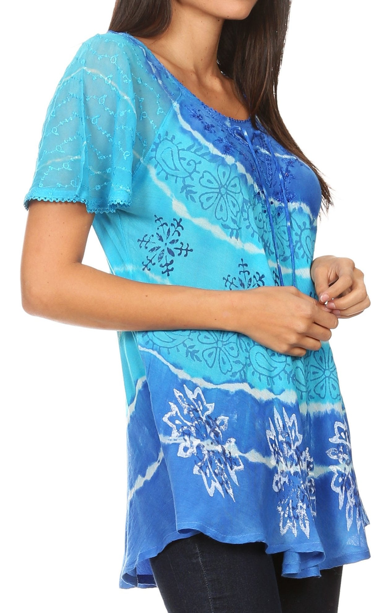 Woman wearing a blue tie-dye top with white patterns on a white background