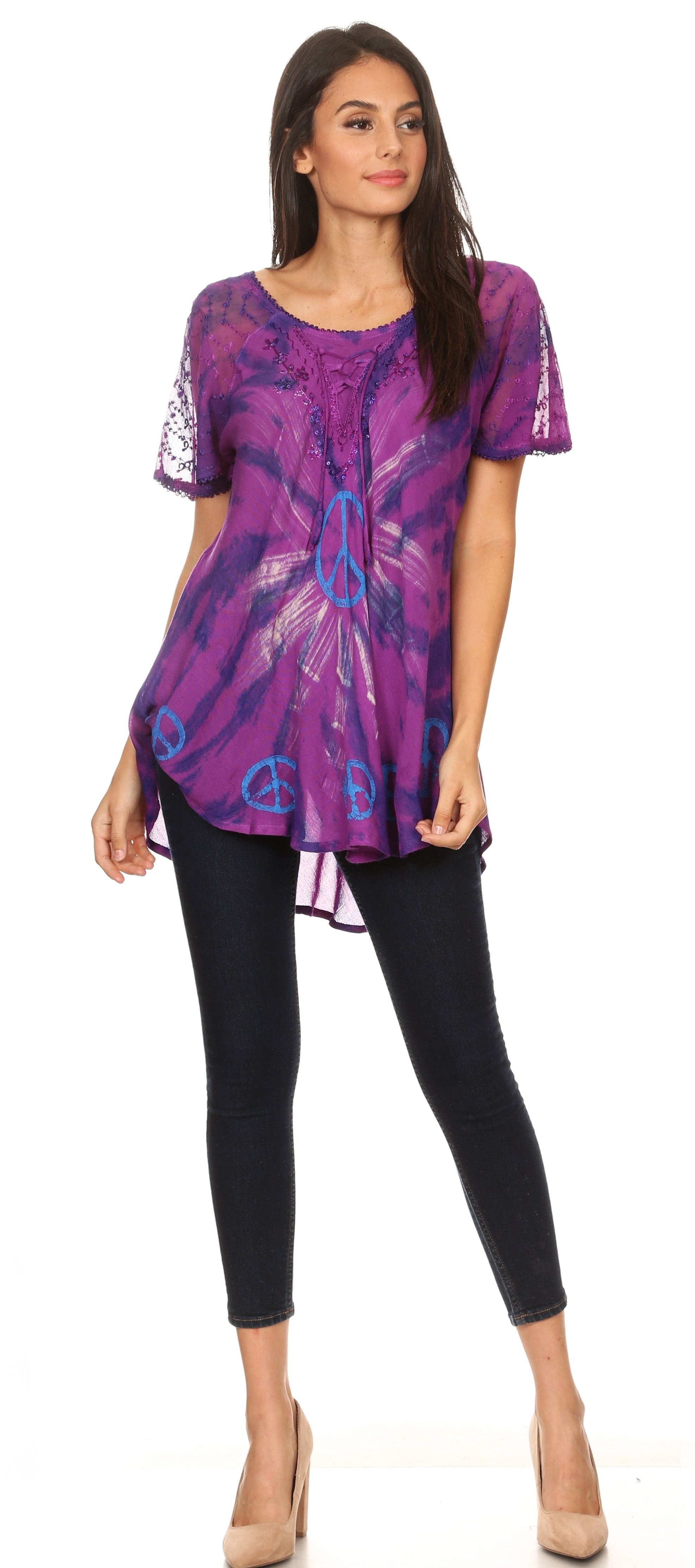 Woman wearing a purple patterned top and black pants on a white background