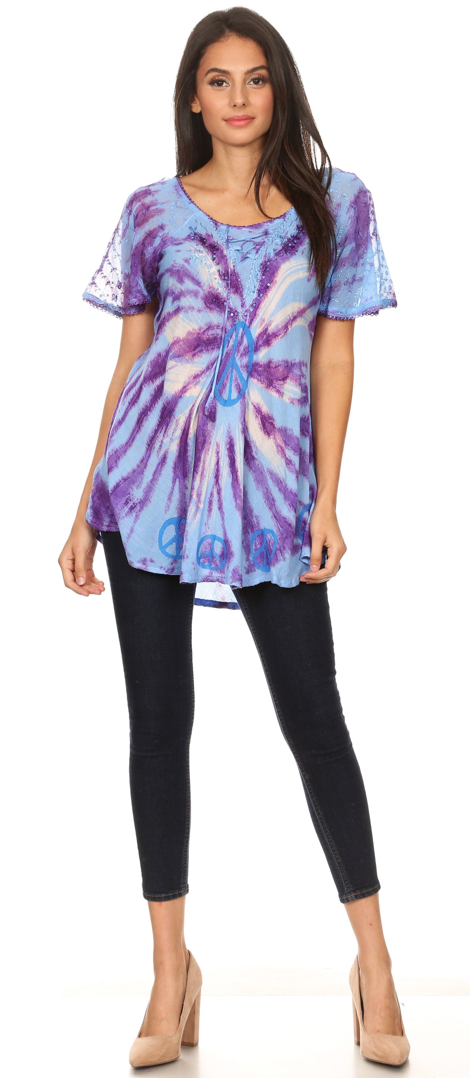 Woman wearing a tie-dye shirt and black pants on a white background