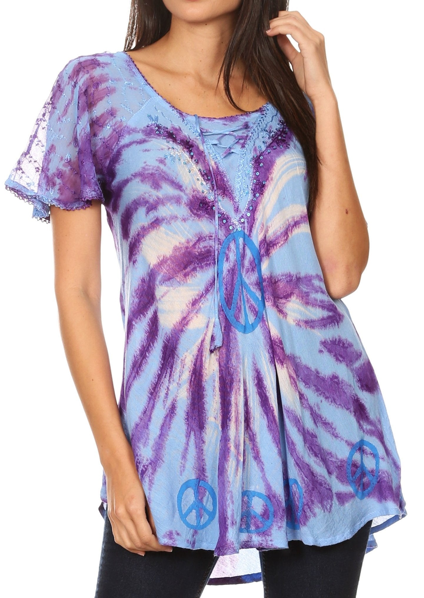 Woman wearing a tie-dye shirt with peace symbol designs on a white background