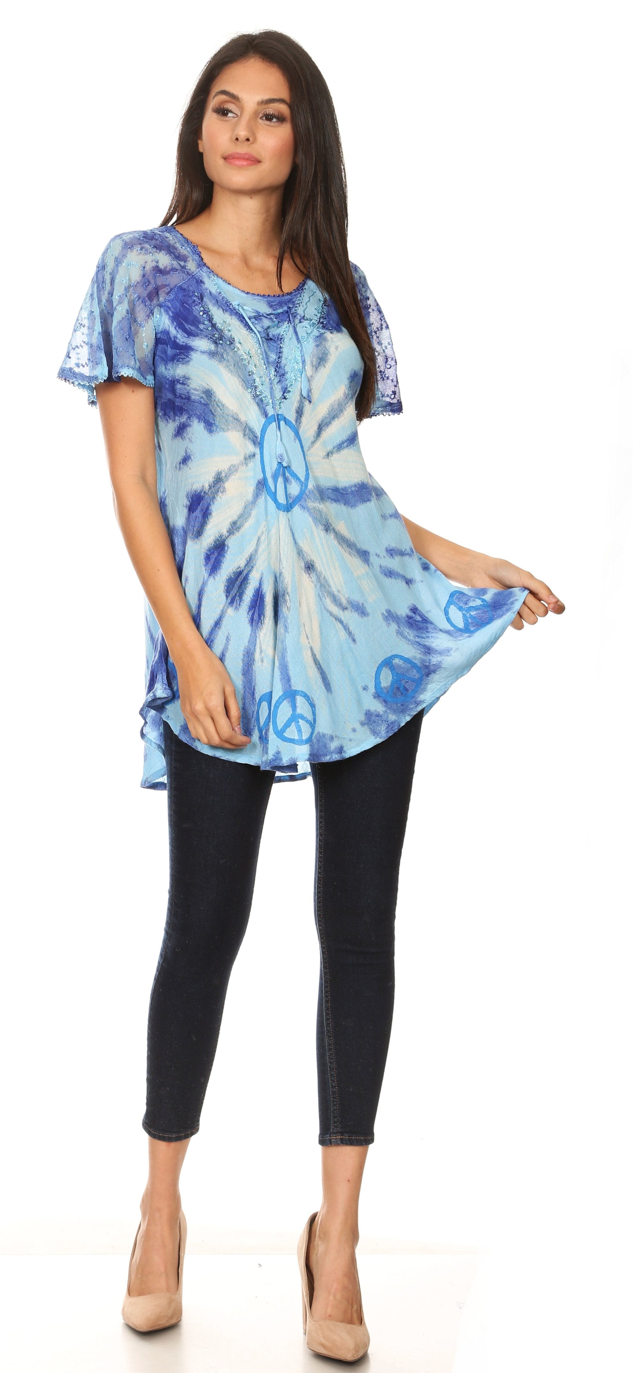 Woman wearing a blue tie-dye top and black pants on a white background