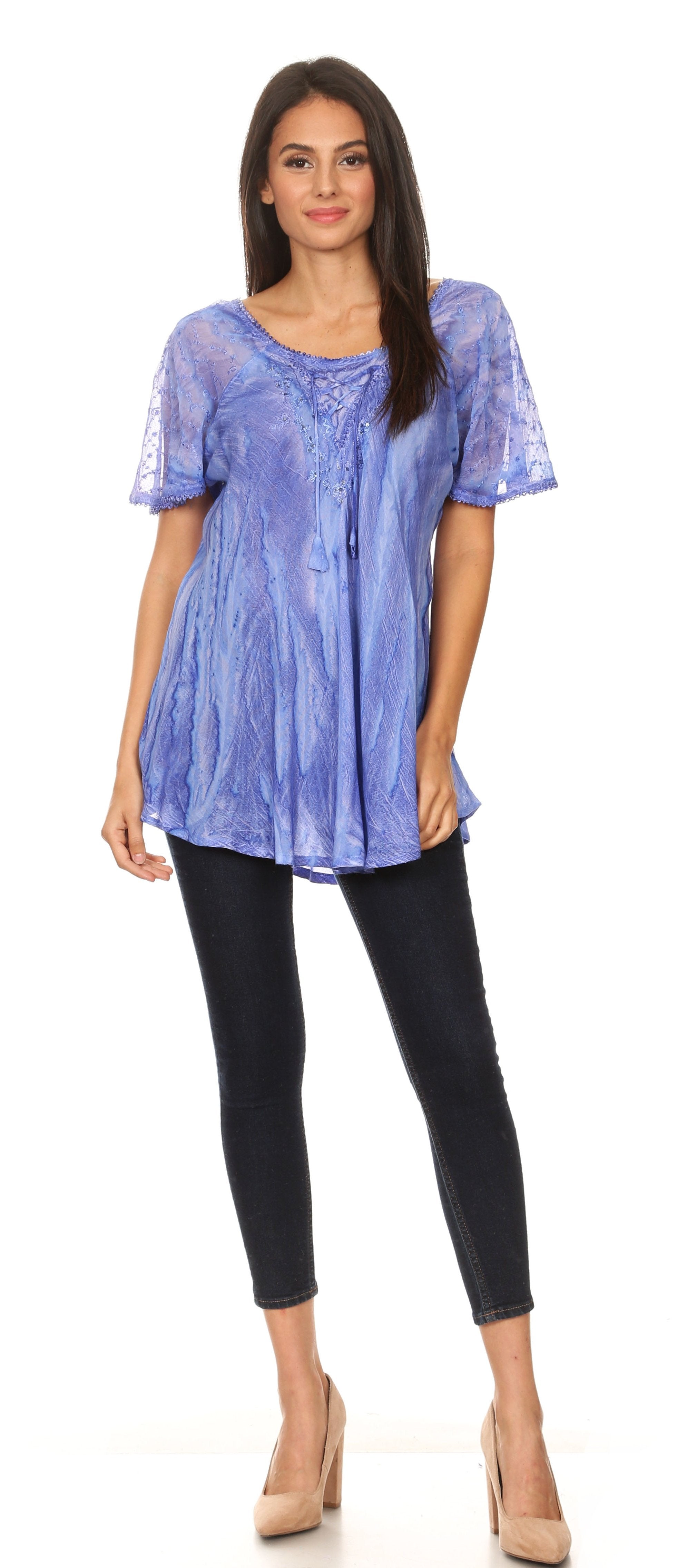 Woman wearing a blue patterned top and black pants on a white background