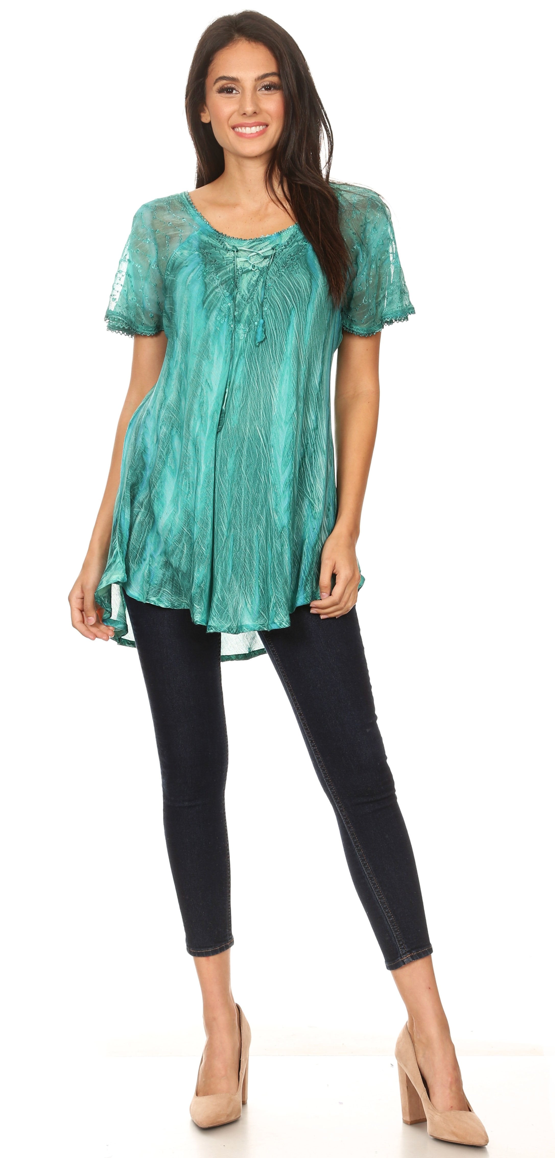 Woman wearing a teal lace top and black leggings on a white background