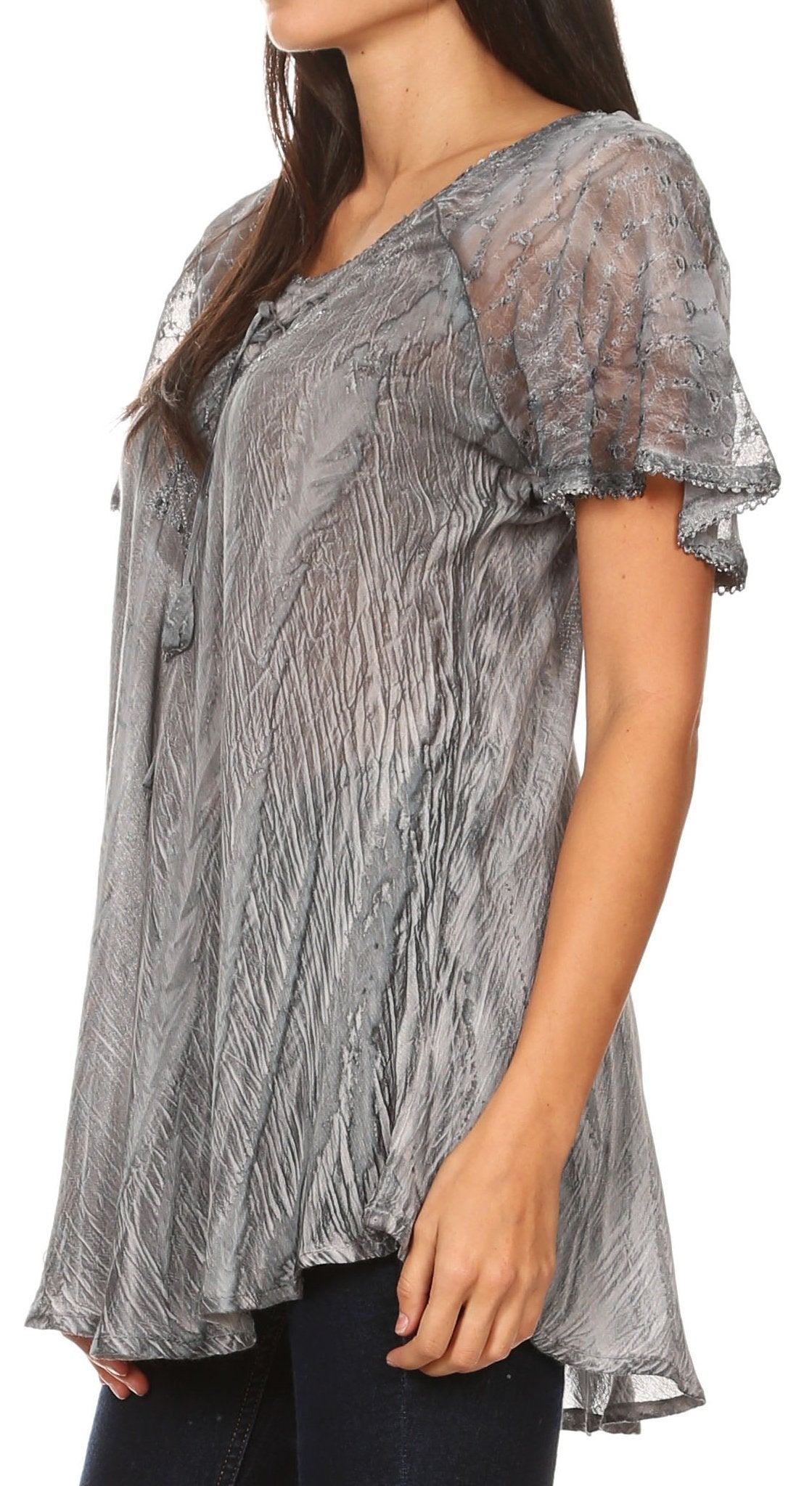 Woman wearing a sheer gray blouse with lace details on a white background