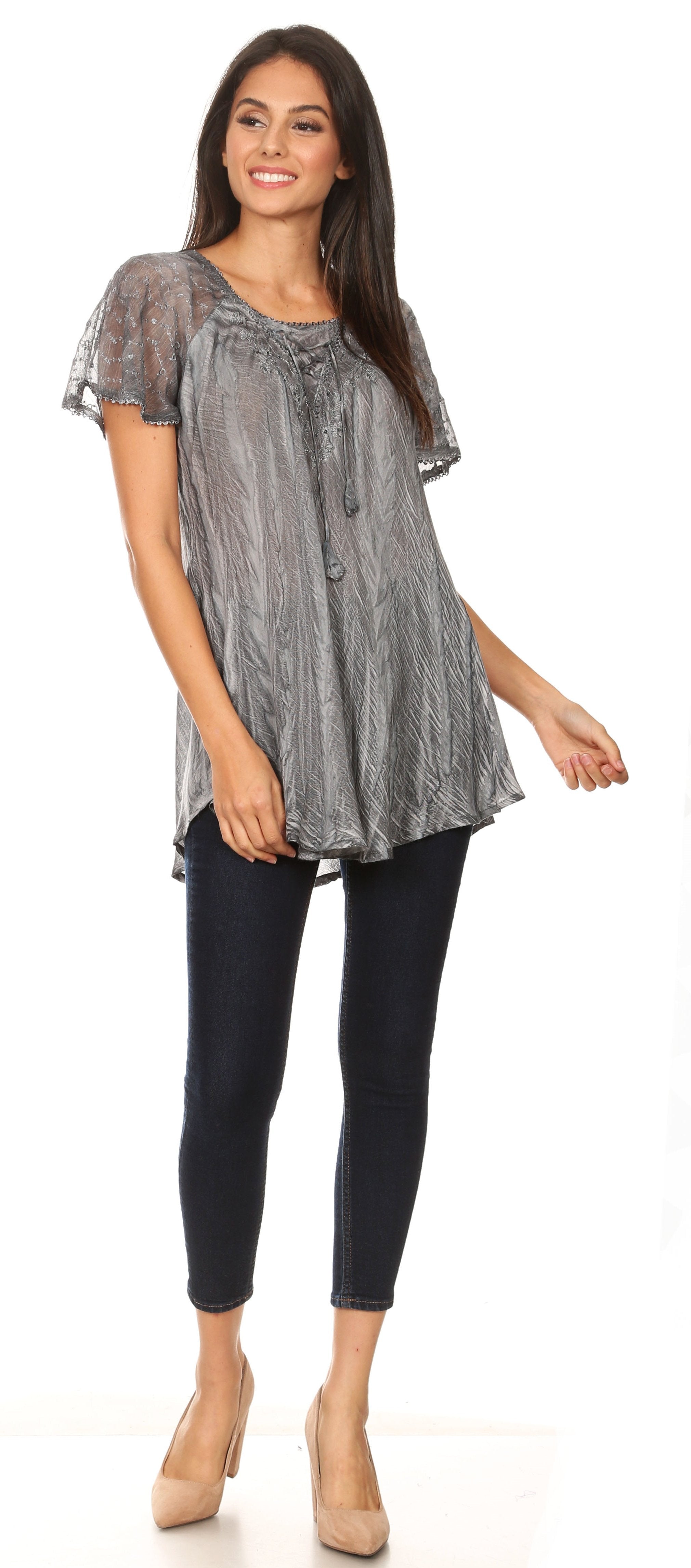 Woman wearing a patterned top and black pants on a white background