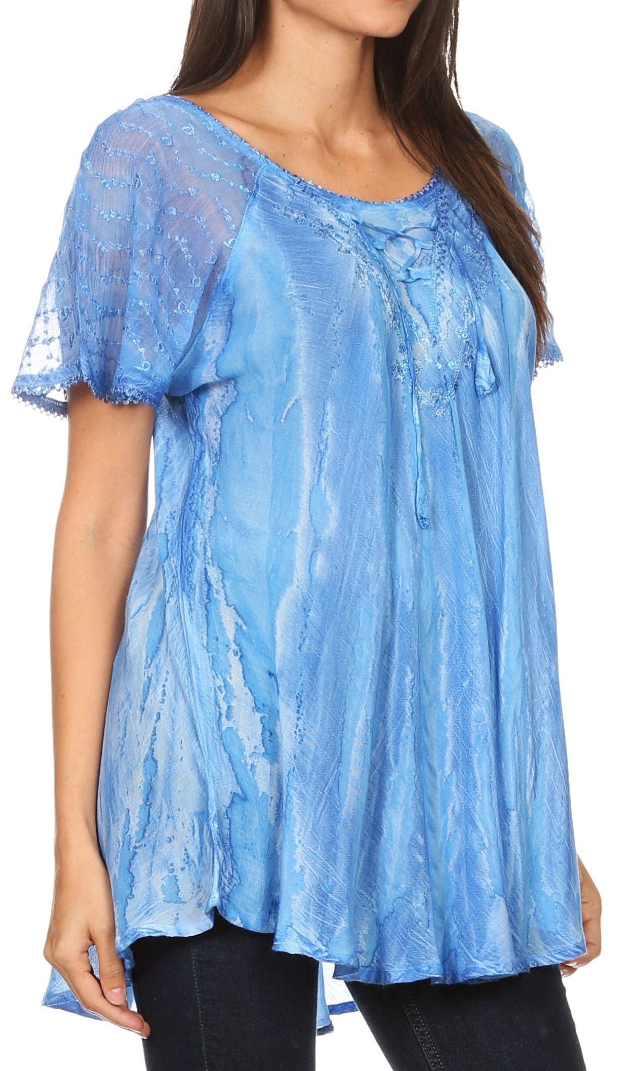 Woman wearing a blue lace top with a plain background