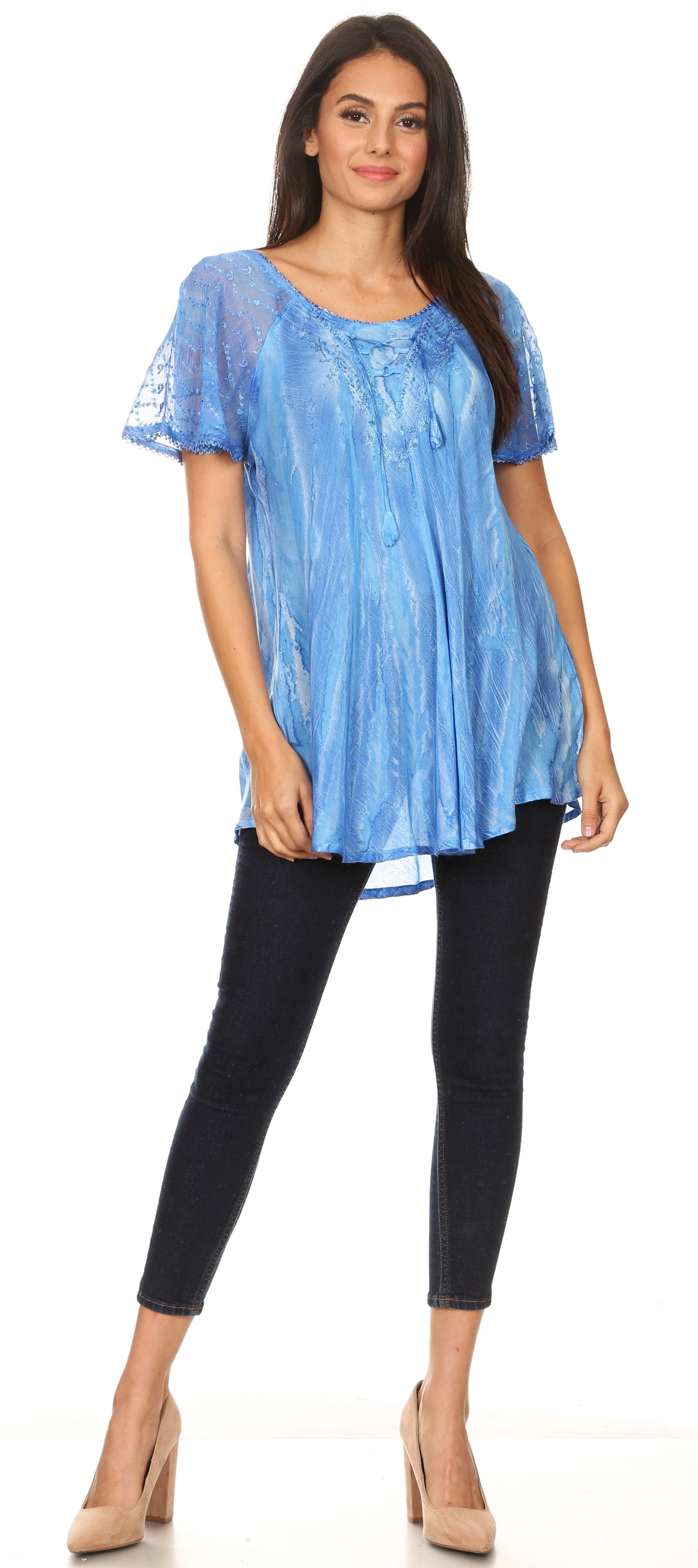 Woman wearing a blue lace top and black pants on a white background