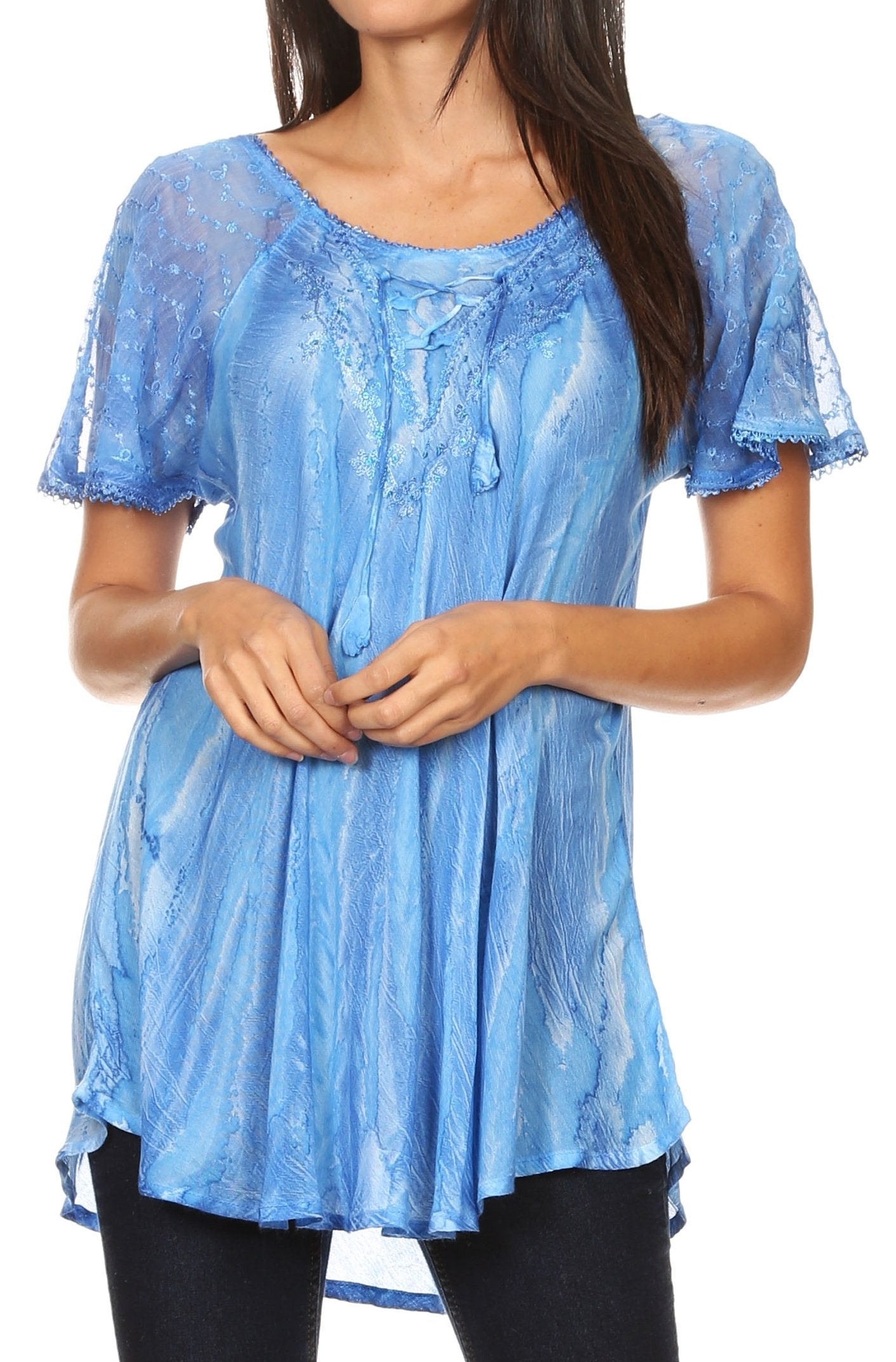 Woman wearing a blue lace top with a plain background