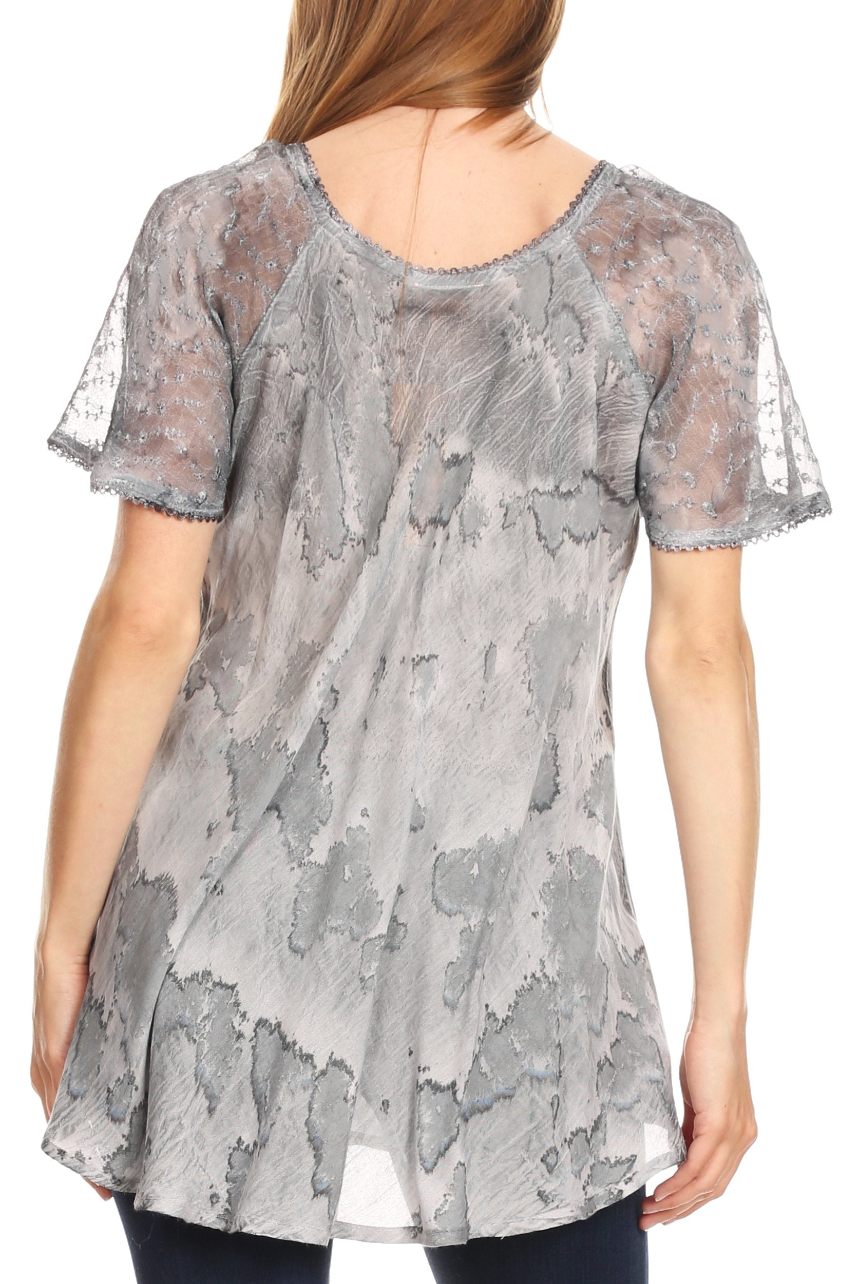 Woman wearing a gray floral lace top on a white background
