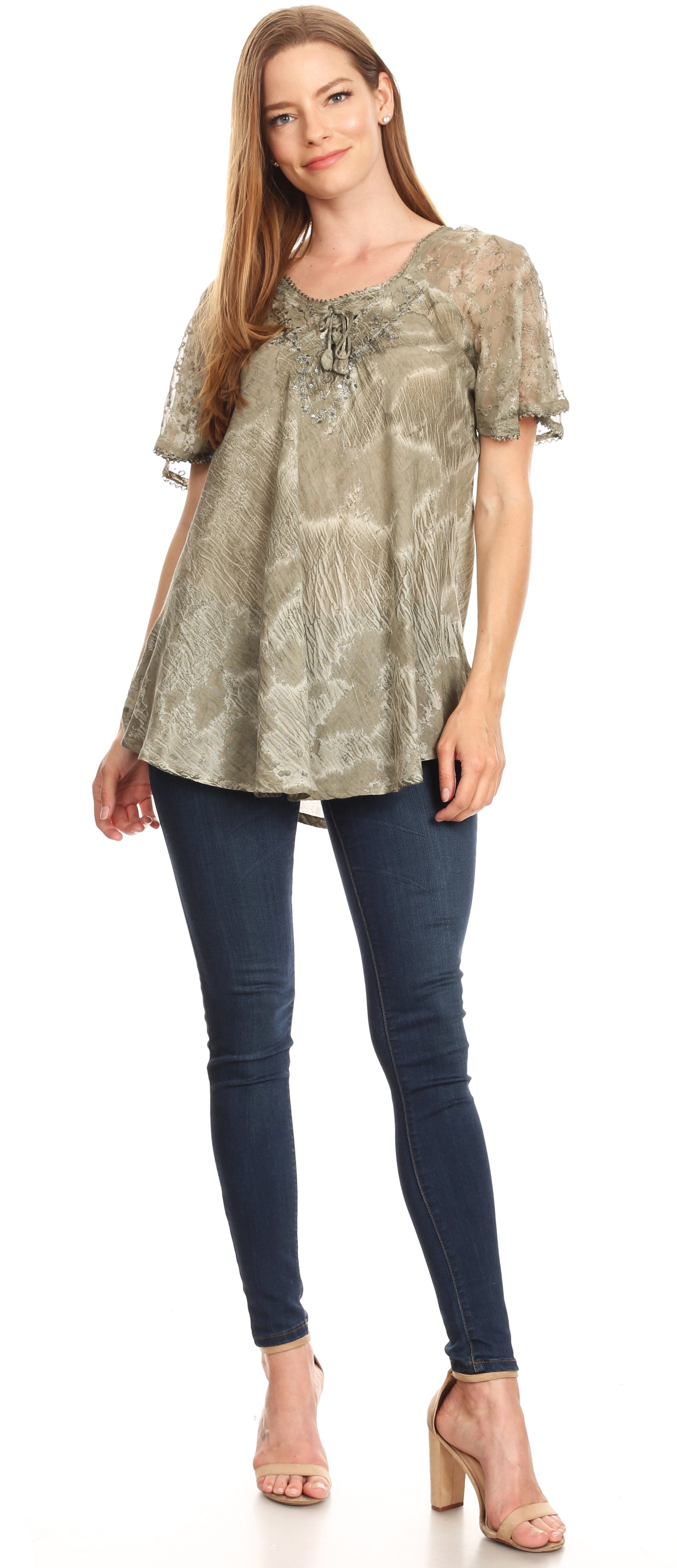 Woman wearing a patterned top and blue jeans on a white background