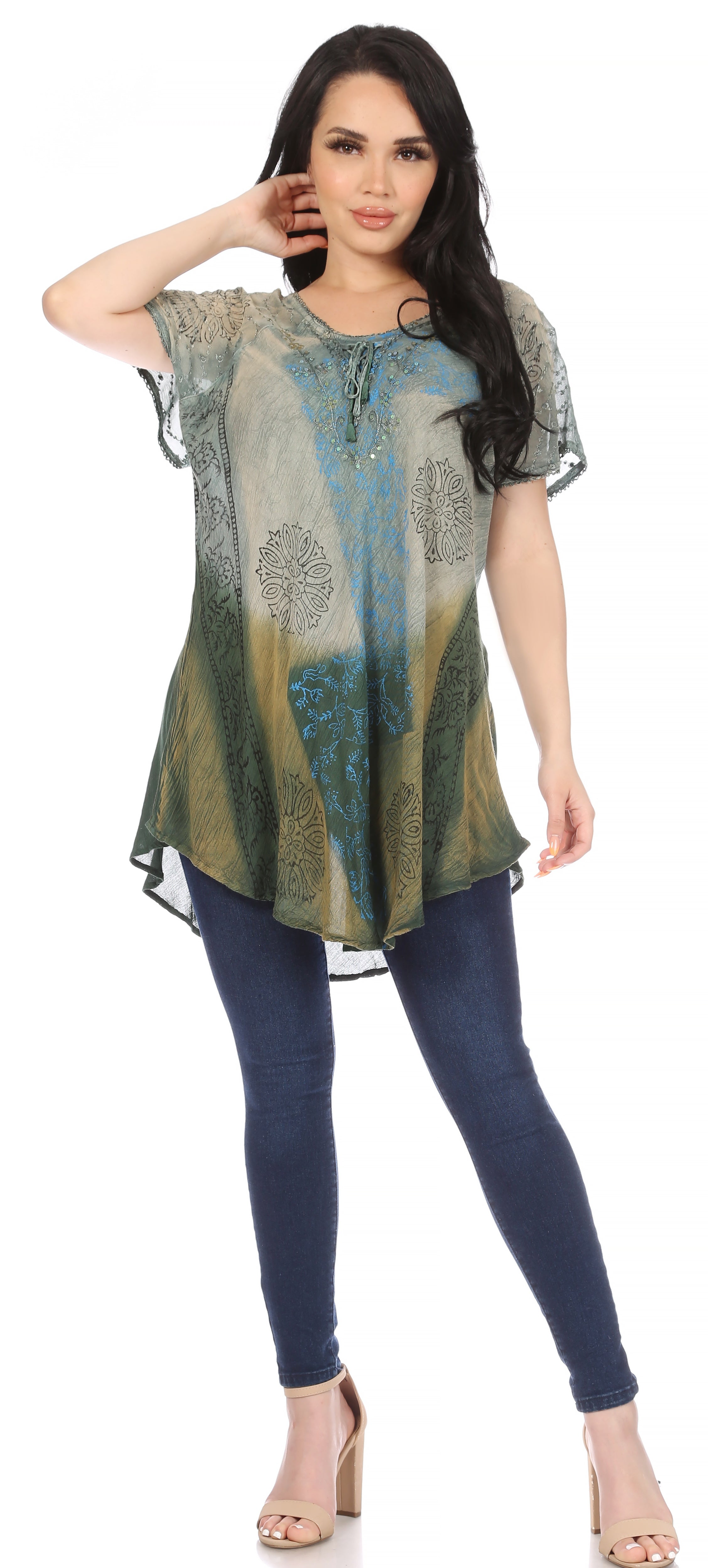 Woman wearing a patterned top and blue jeans on a white background
