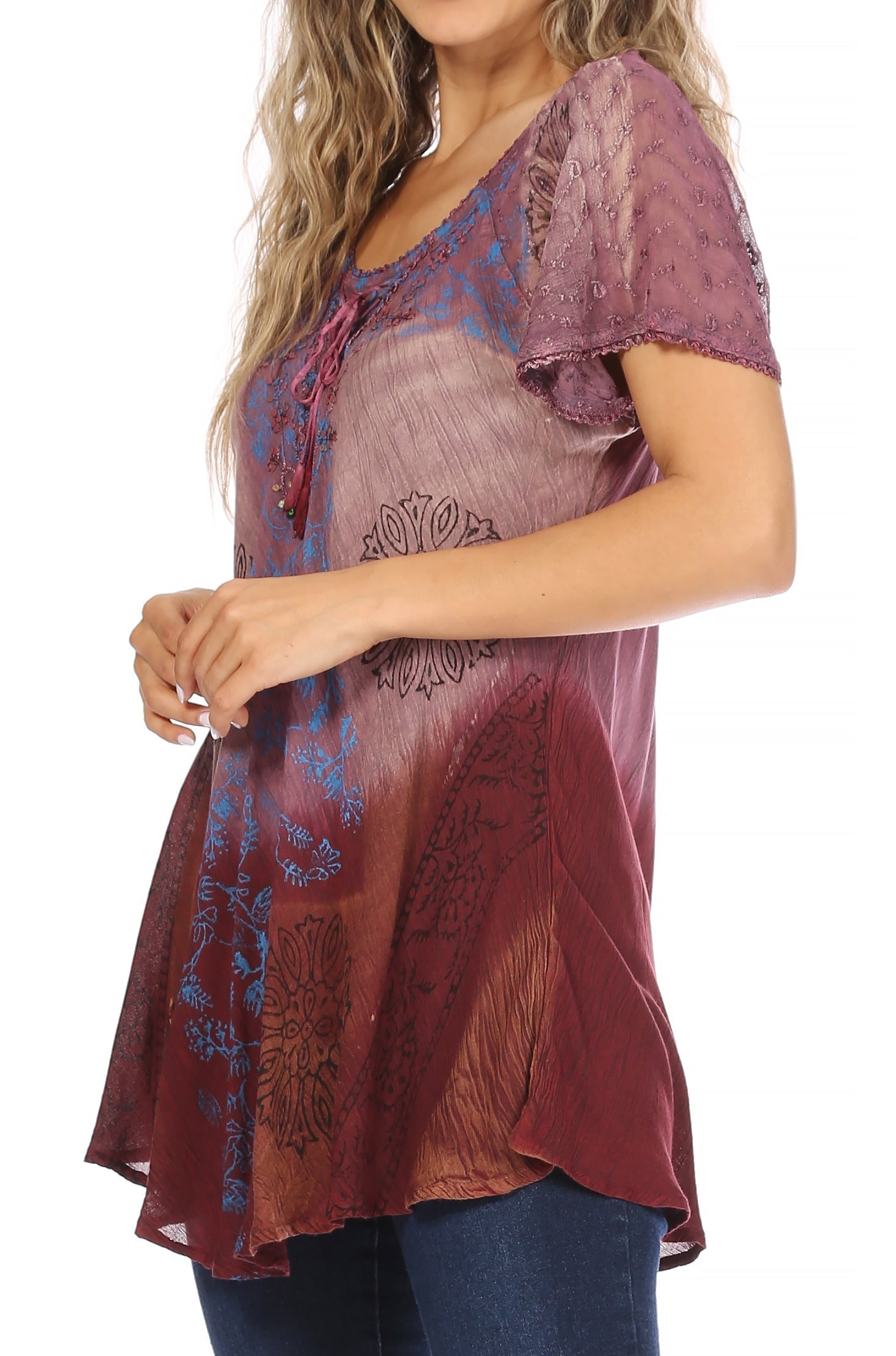Woman wearing a burgundy and purple patterned top on a white background