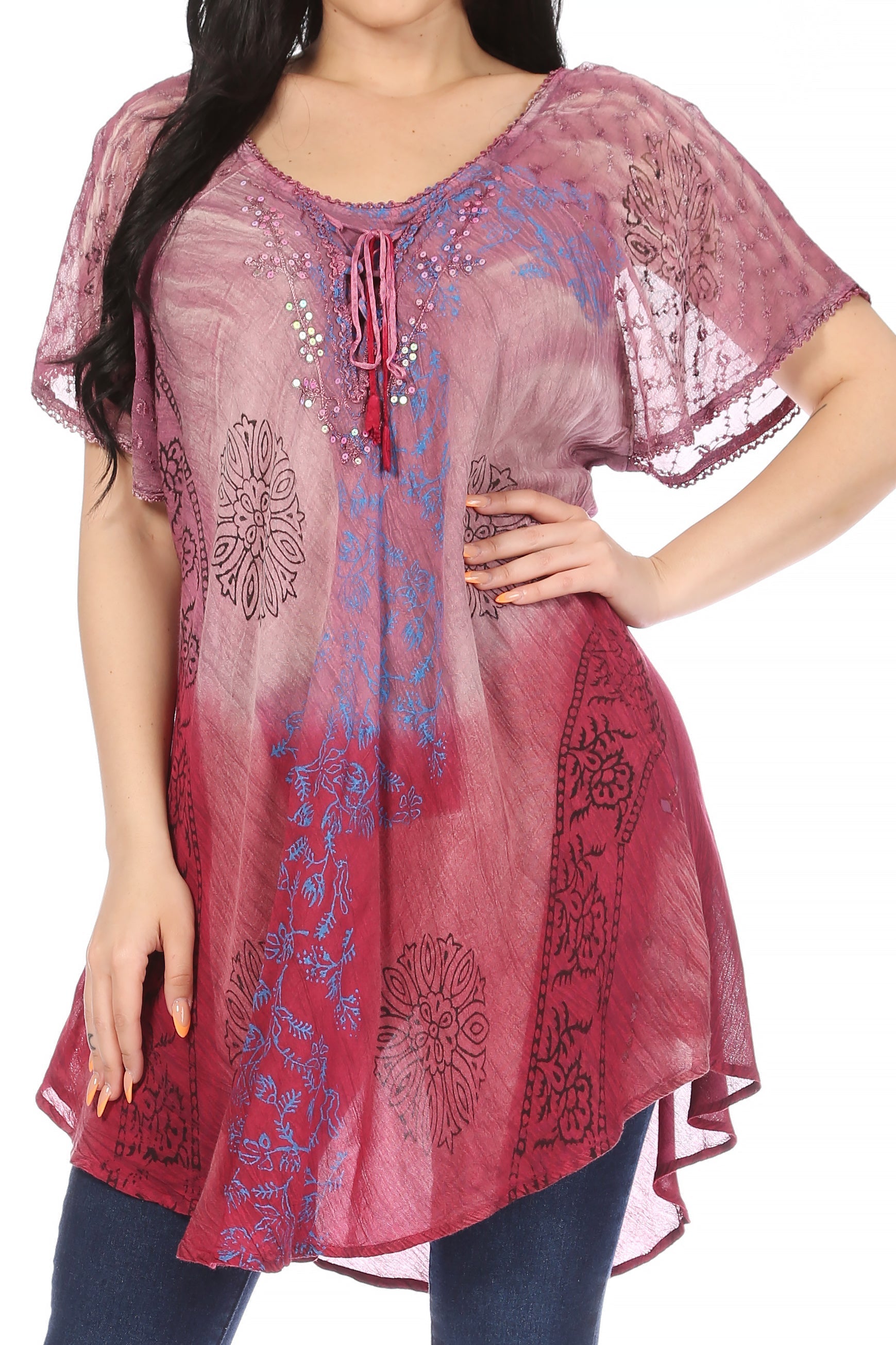 Woman wearing a pink floral embroidered top with a blurred background