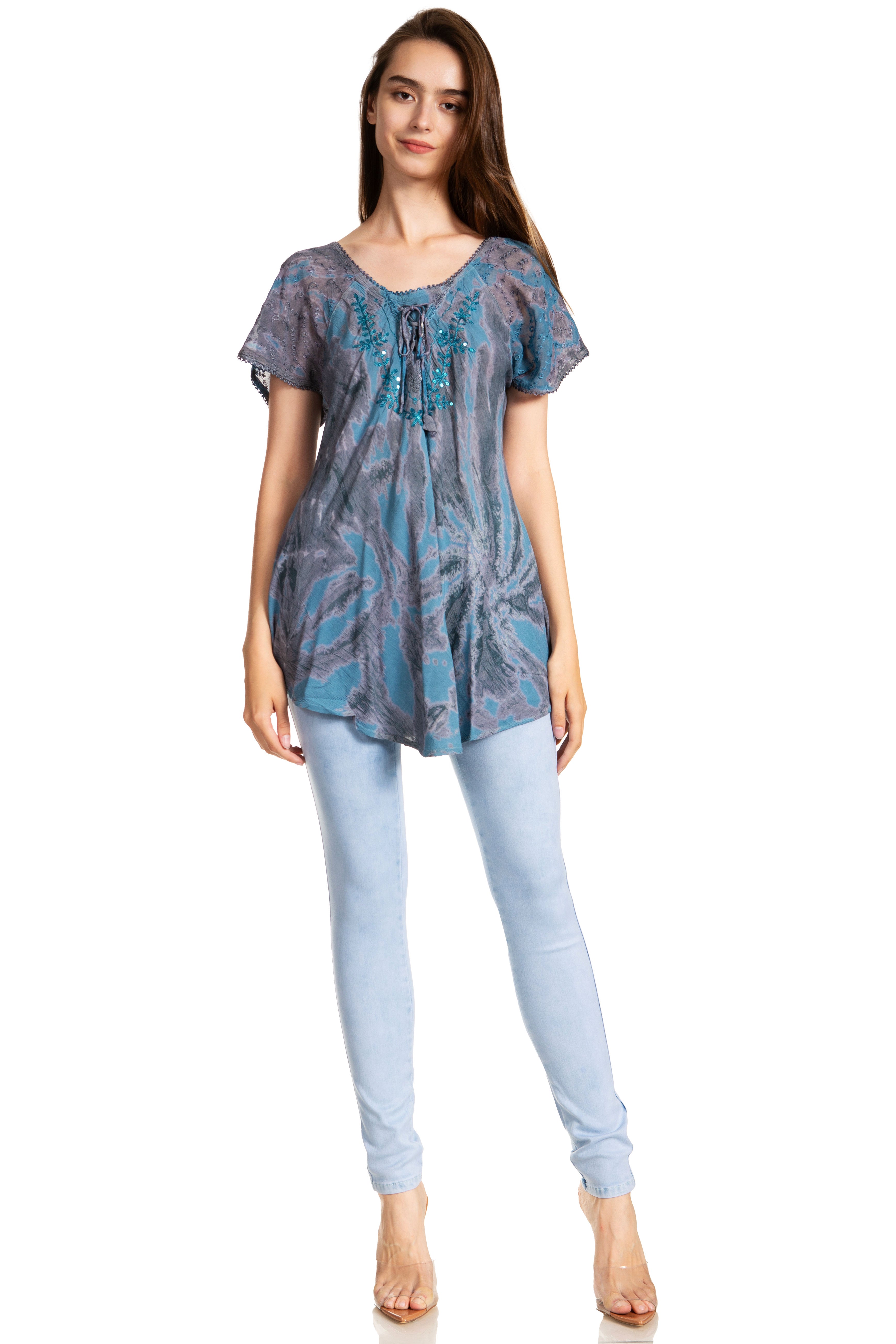 Woman wearing a patterned blue top and light blue jeans on a white background