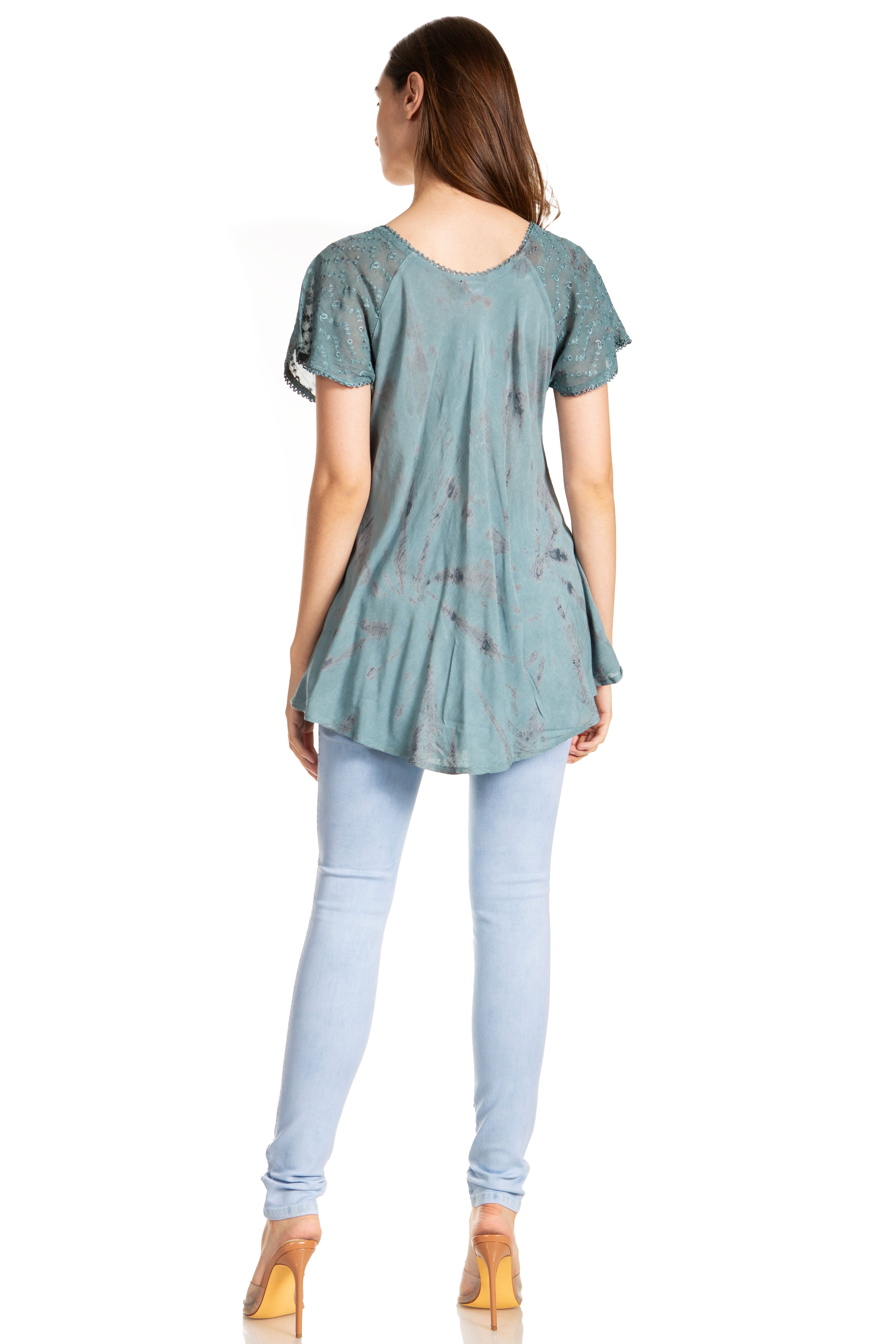Woman wearing a green tunic and light blue leggings on a white background