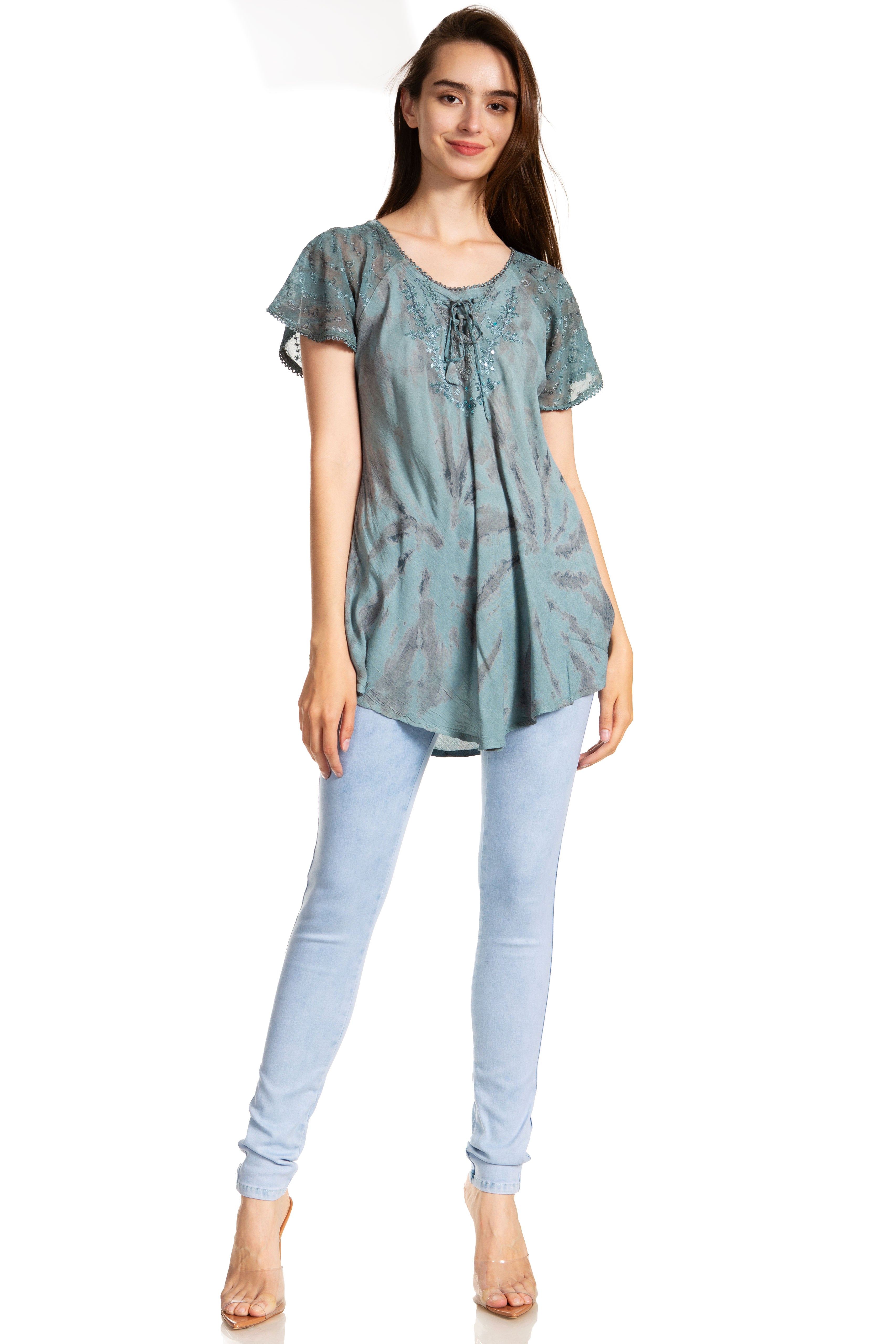 Woman wearing a light blue patterned top and light blue jeans on a white background