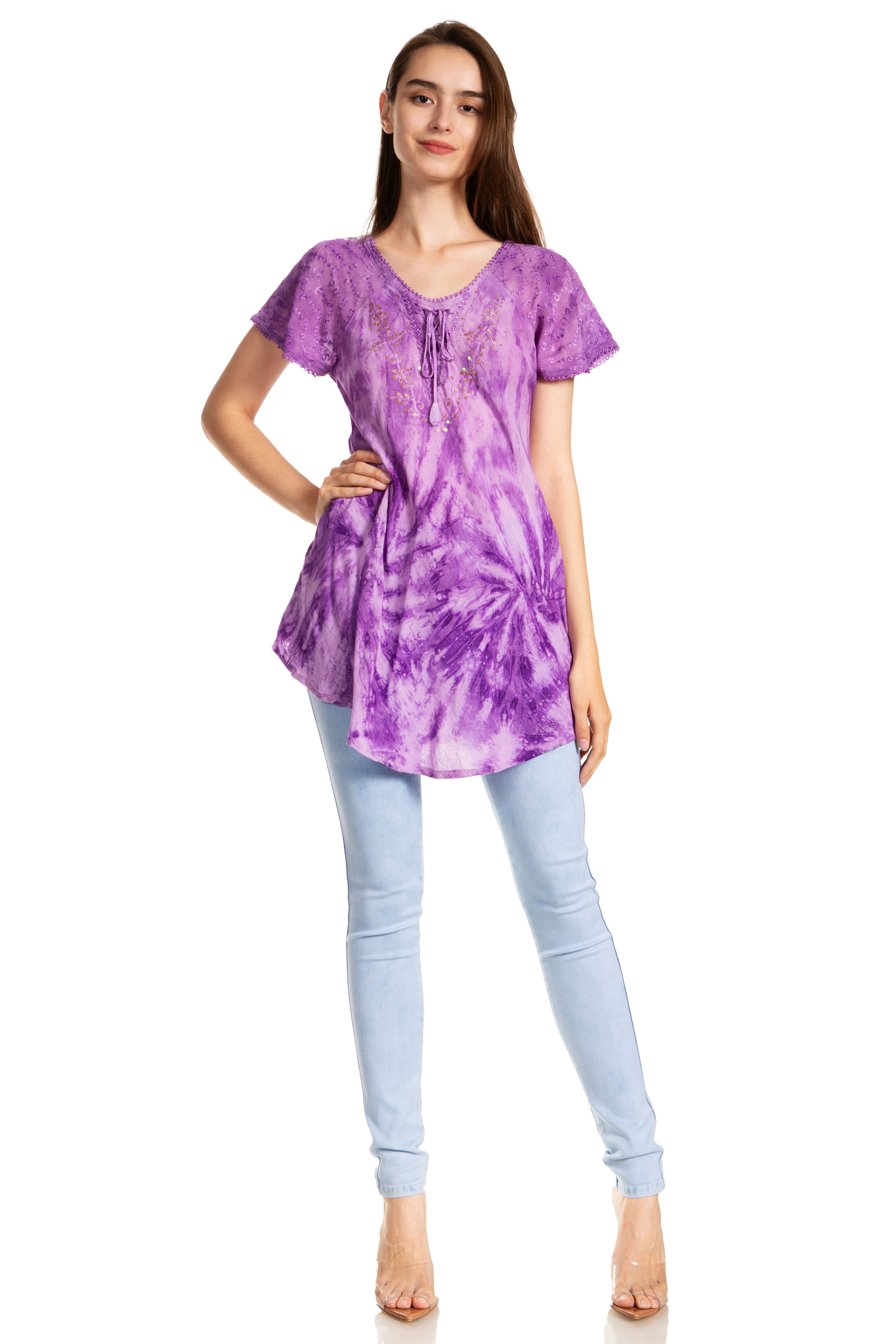 Woman wearing a purple tie-dye top and light blue jeans on a white background
