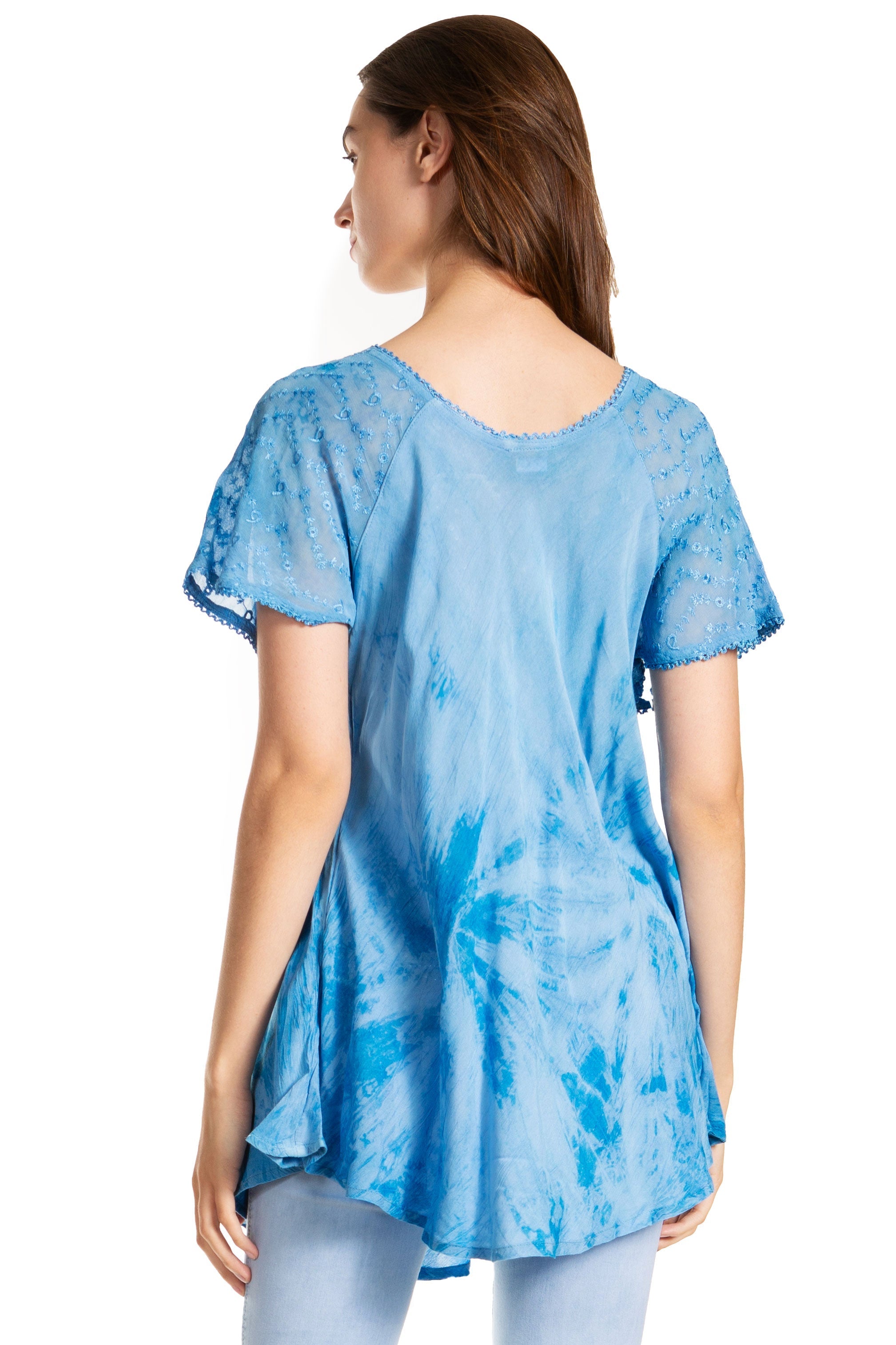 Woman wearing a blue tie-dye tunic with lace sleeves on a white background