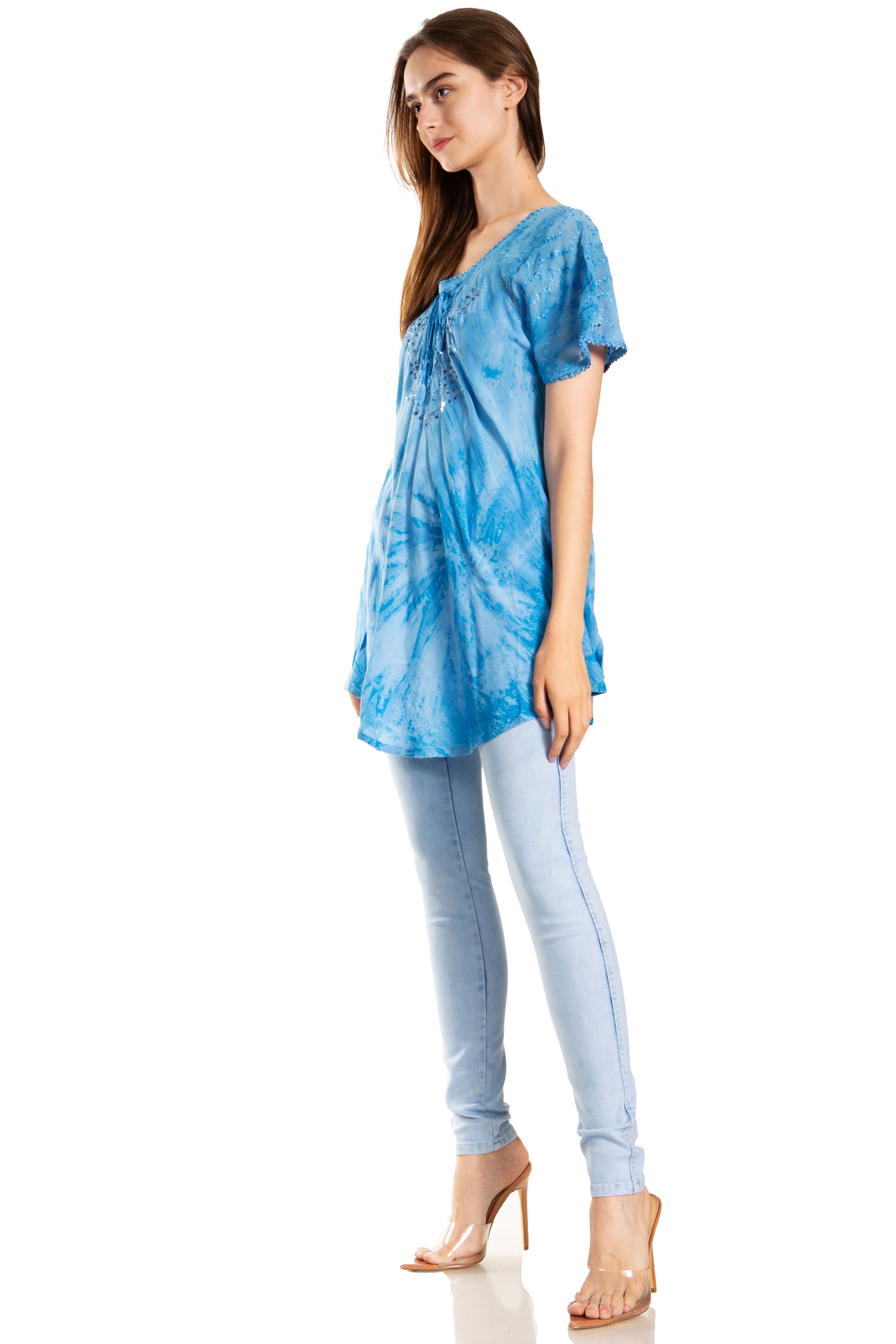 Woman wearing a blue tie-dye top and light blue pants on a white background
