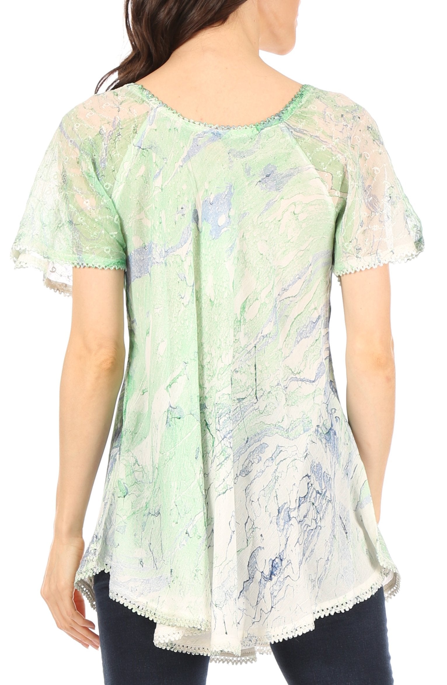 Woman wearing a light green floral blouse with lace trim on a white background