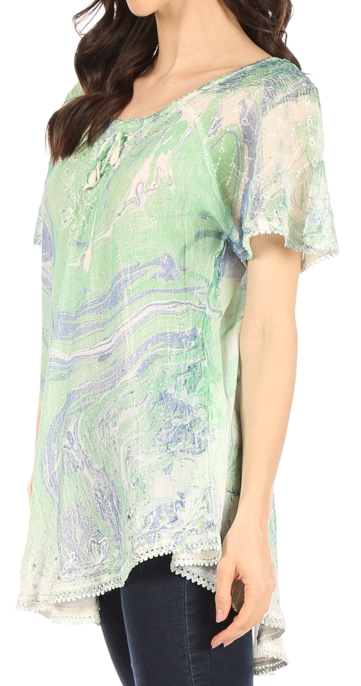 Woman wearing a green and white patterned blouse with short sleeves.