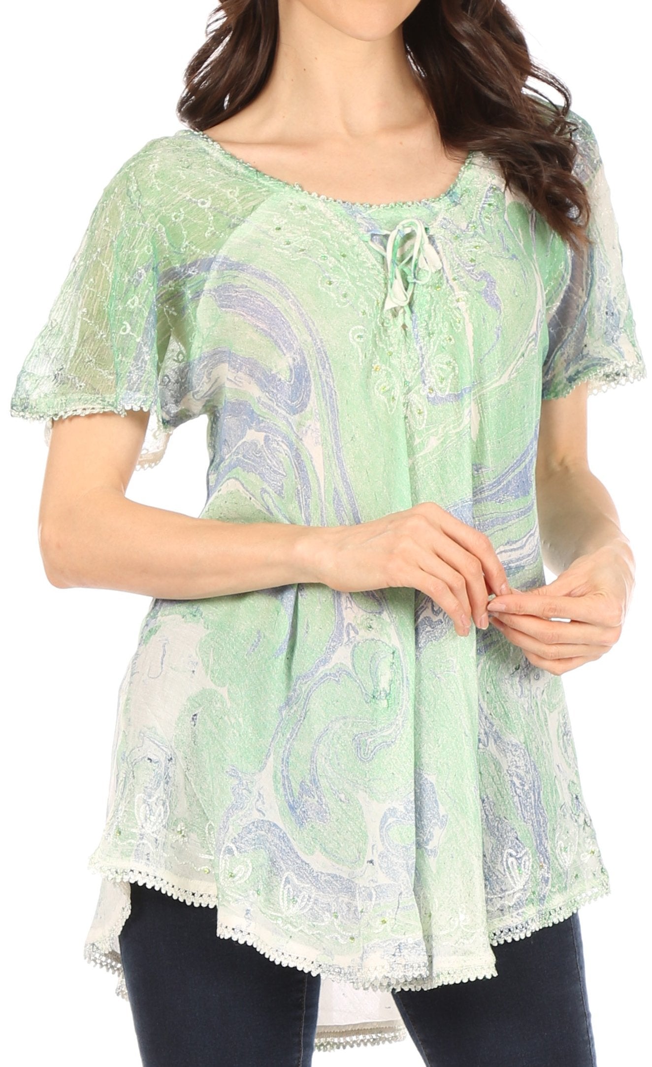 Woman wearing a green and white patterned blouse with a plain background