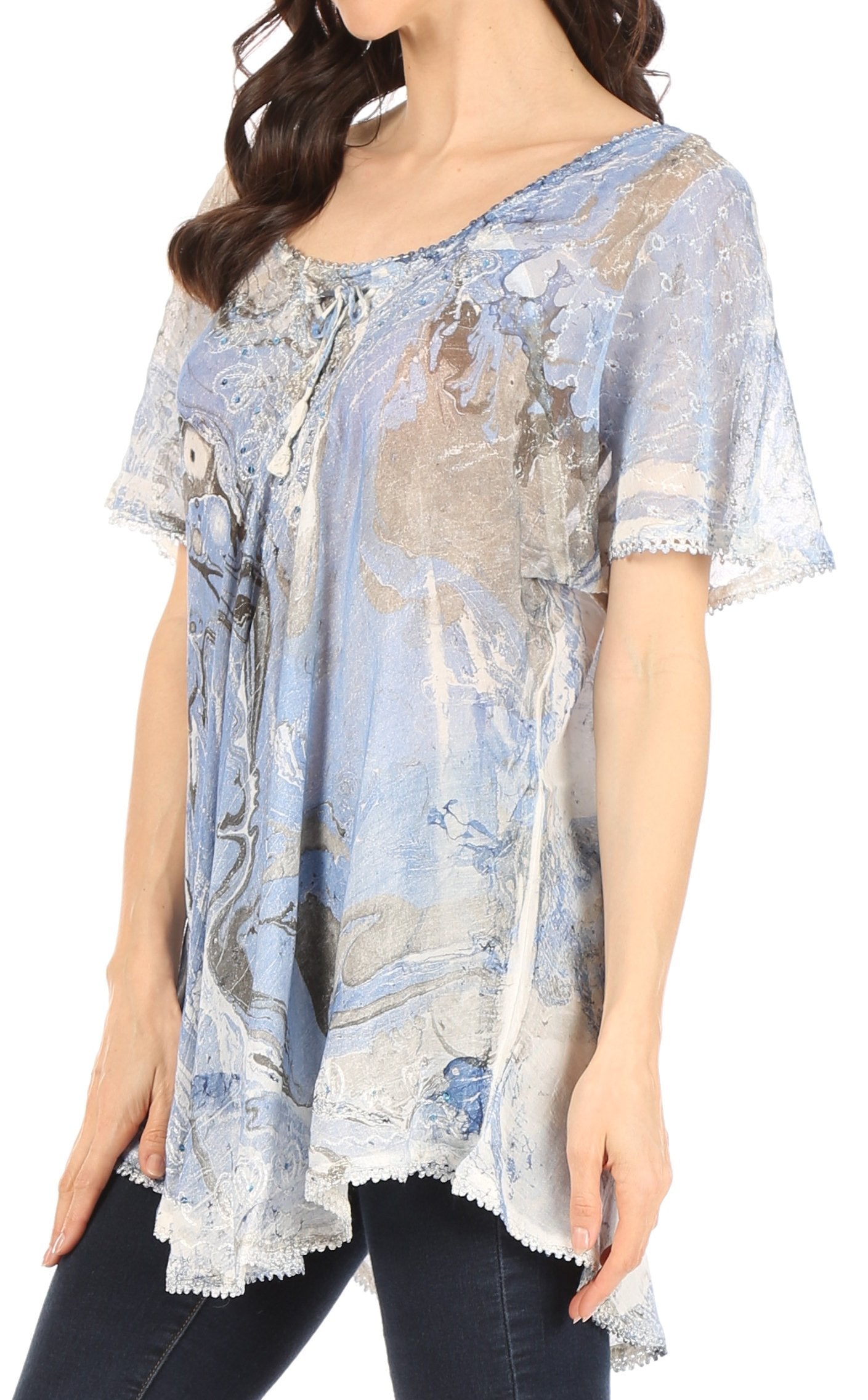 Woman wearing a floral patterned blouse with lace trim on a plain background